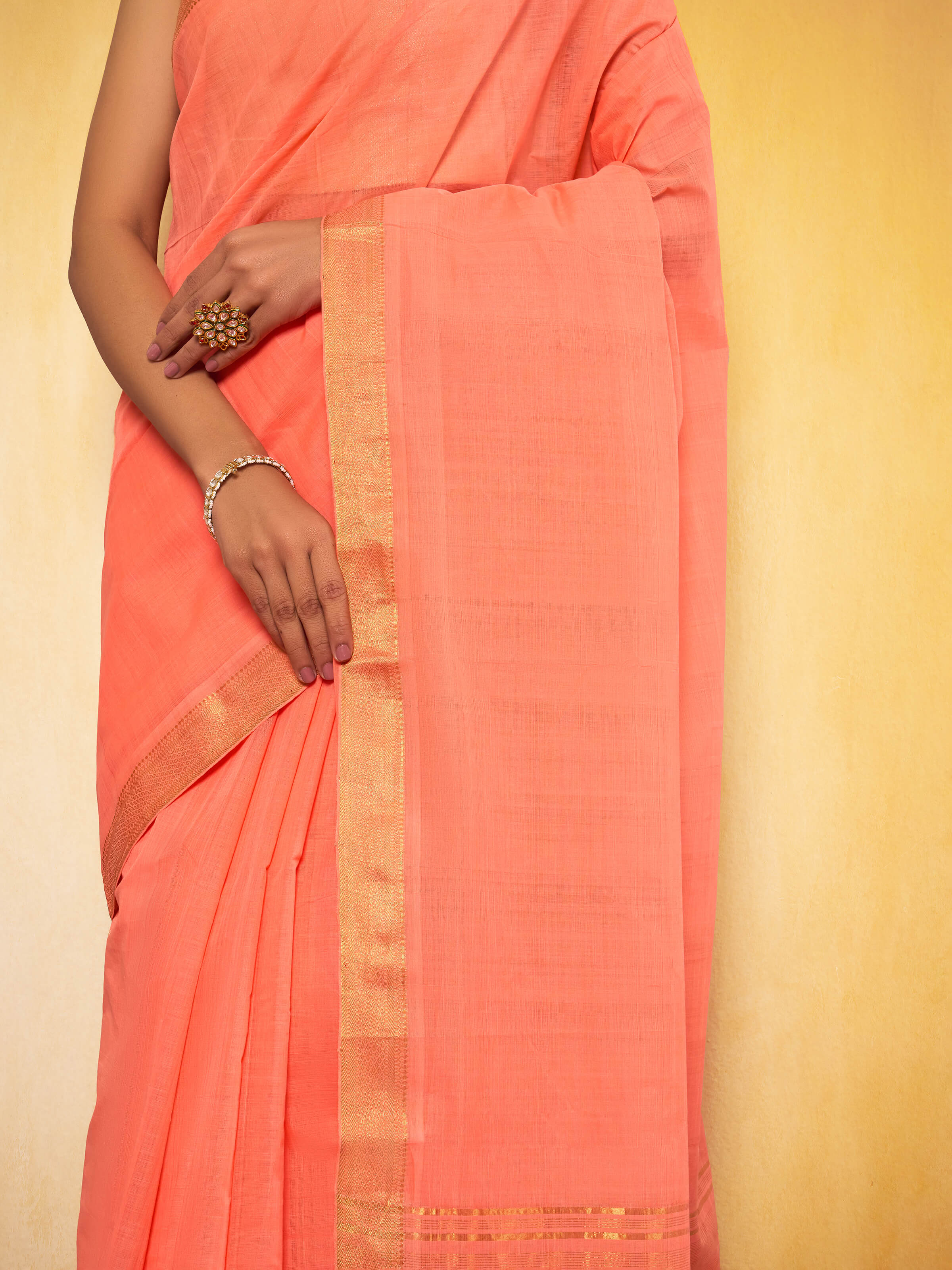 Detail shot of peach Mangalgiri saree highlighting weaving style and fabric finish.