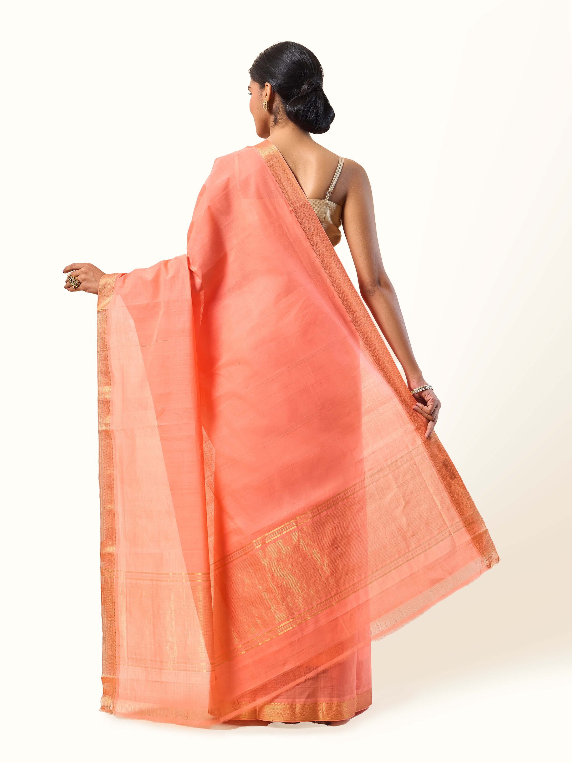 Back view of peach cotton Mangalgiri saree displaying pleats and border fall.