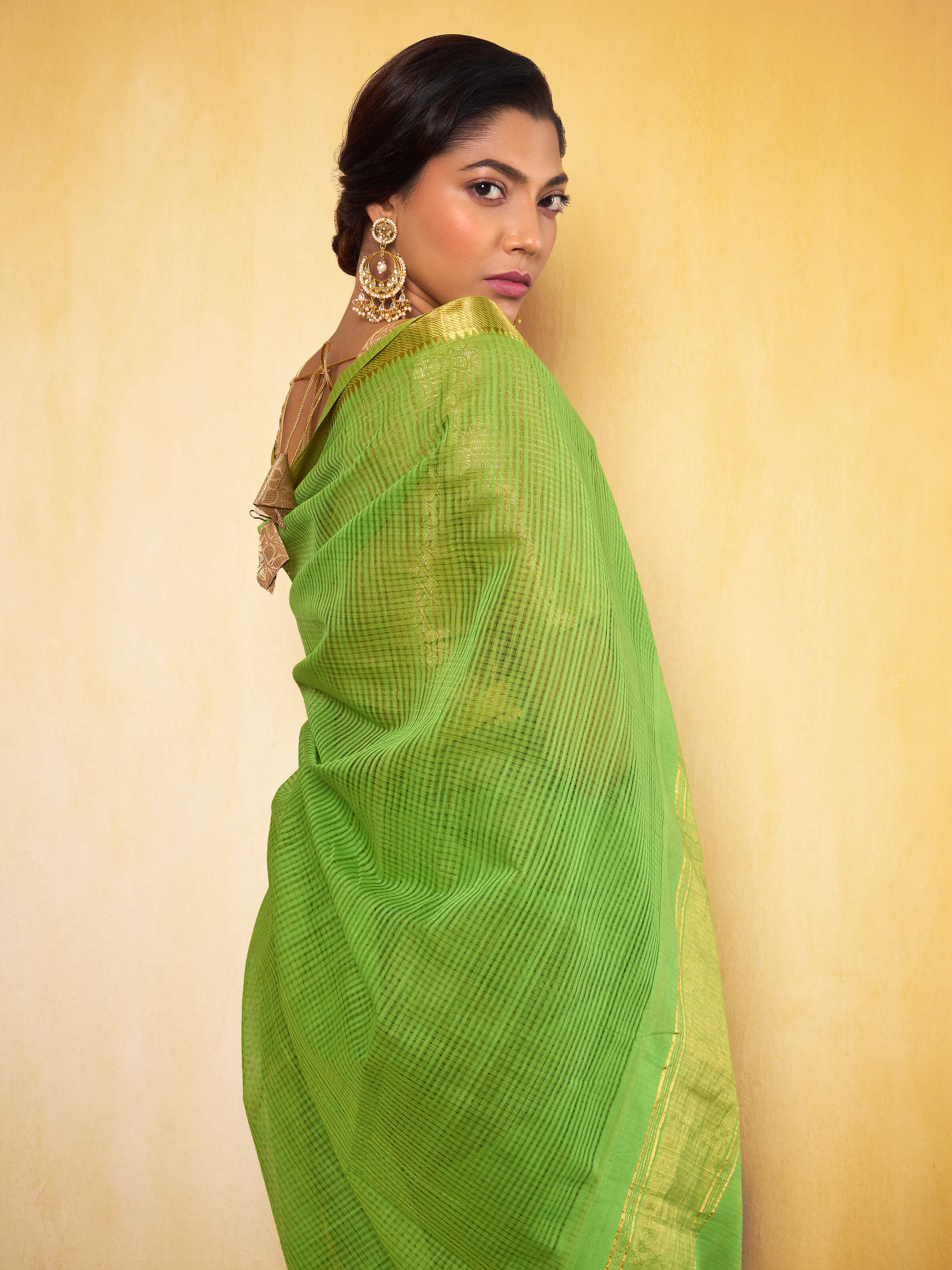 Angled view of light green cotton Mangalgiri saree highlighting its minimalistic elegance and drape.