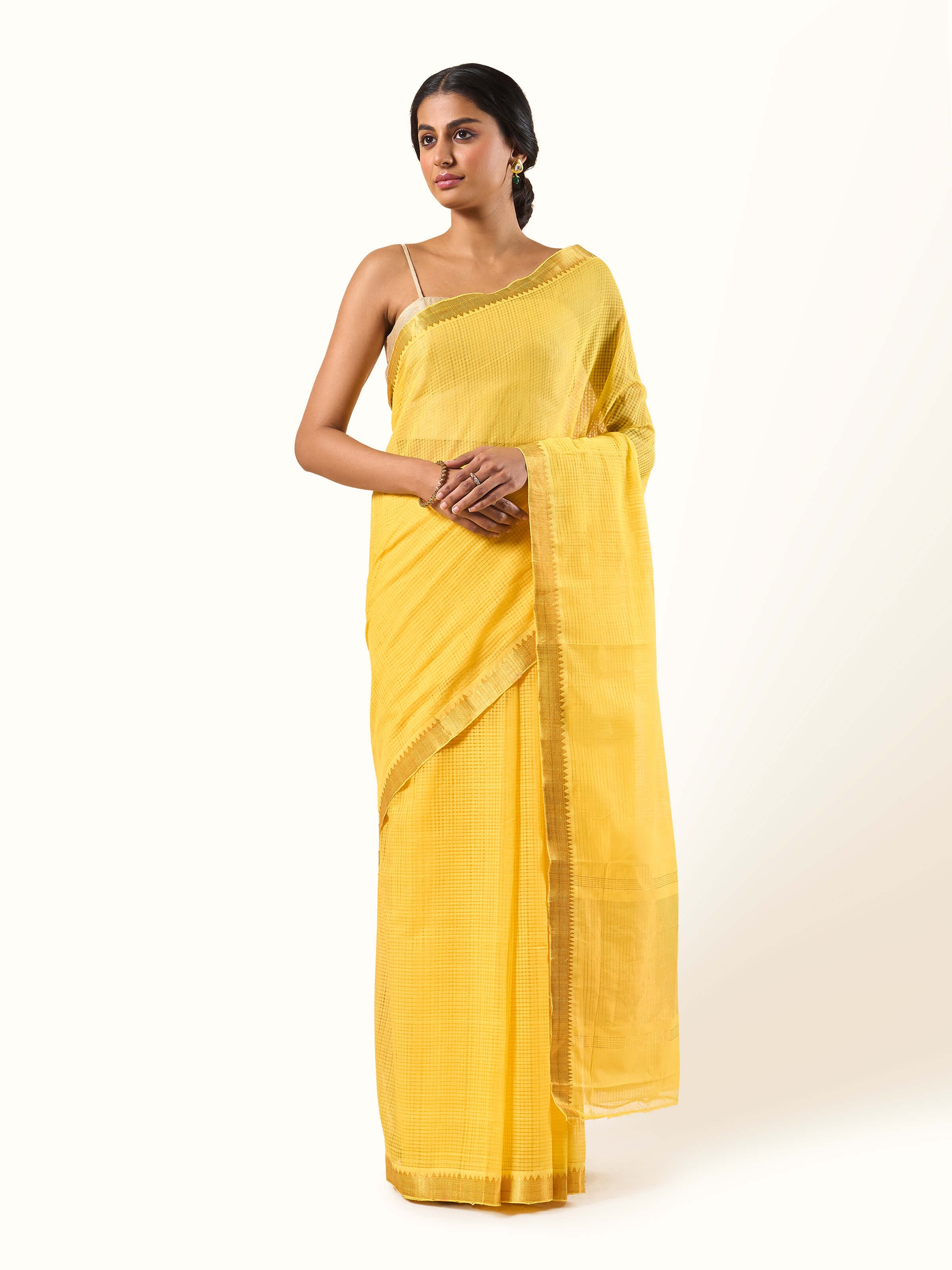 Front view of yellow and gold cotton Mangalgiri saree with fine border and traditional weave.