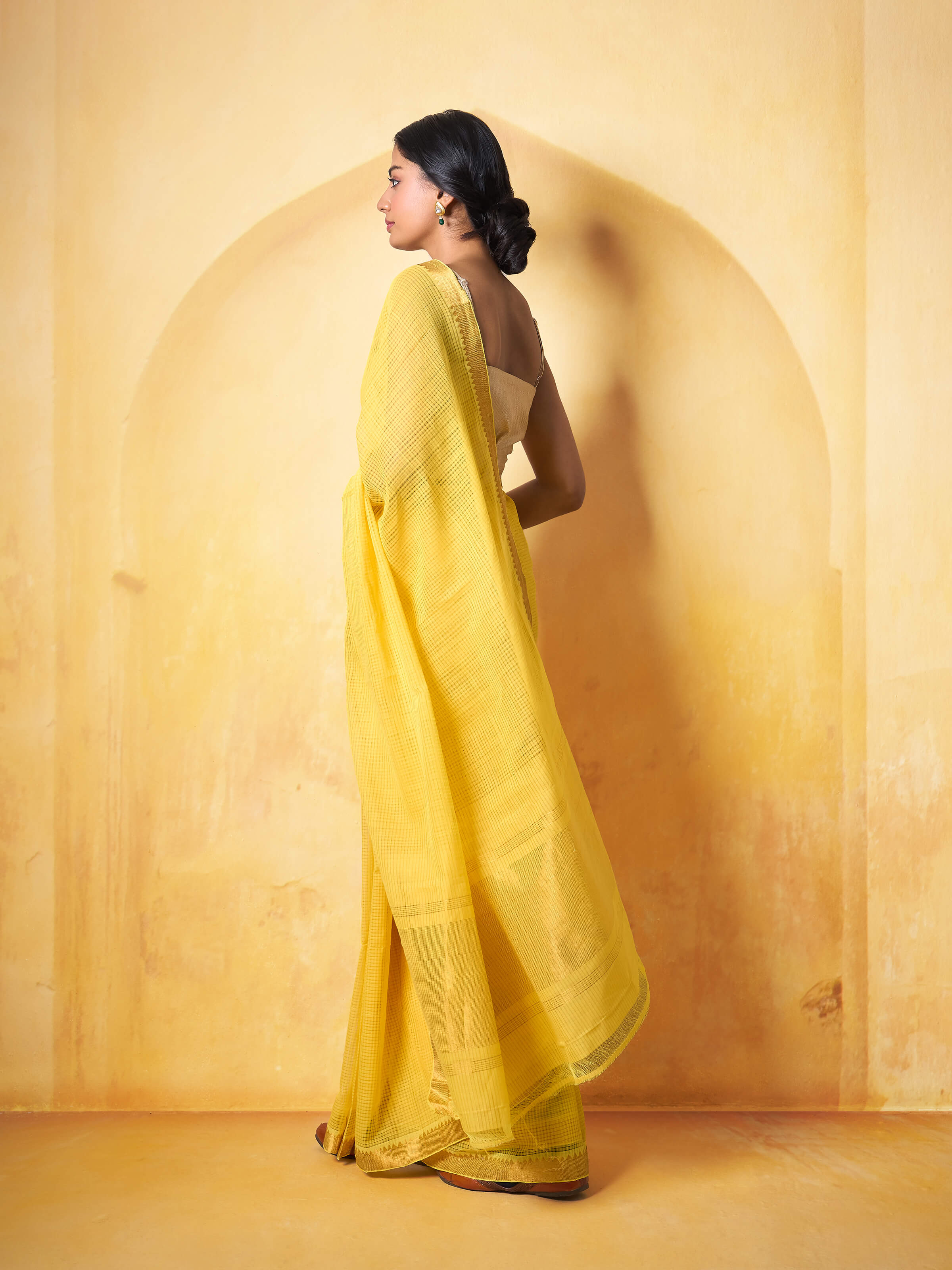 Angled view of yellow Mangalgiri cotton saree capturing its elegant texture and border.