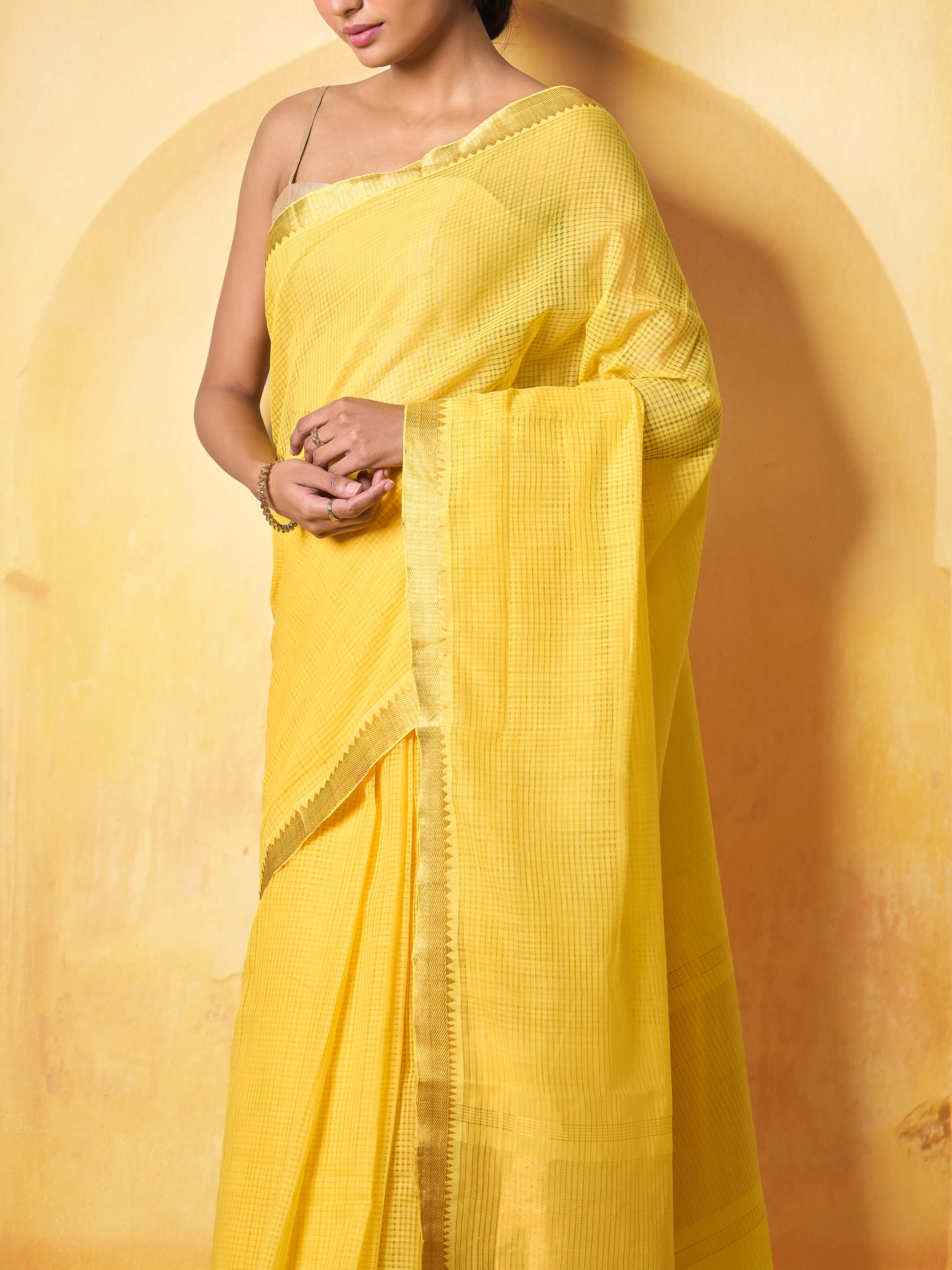 Detail shot of yellow cotton Mangalgiri saree showing gold border and handwoven finish.