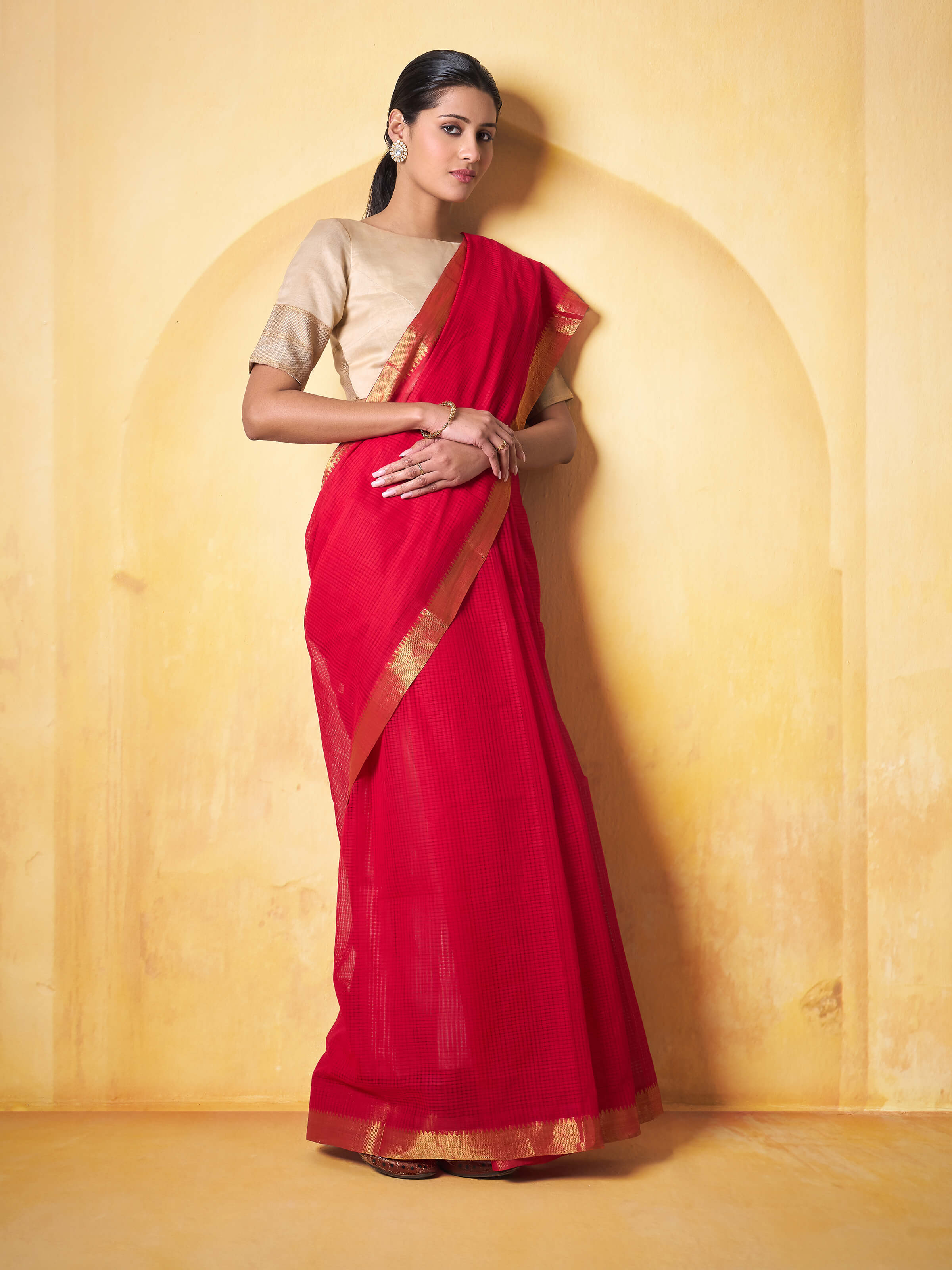 Lifestyle shot of model draped in Red Mangalgiri Saree with minimal jewelry