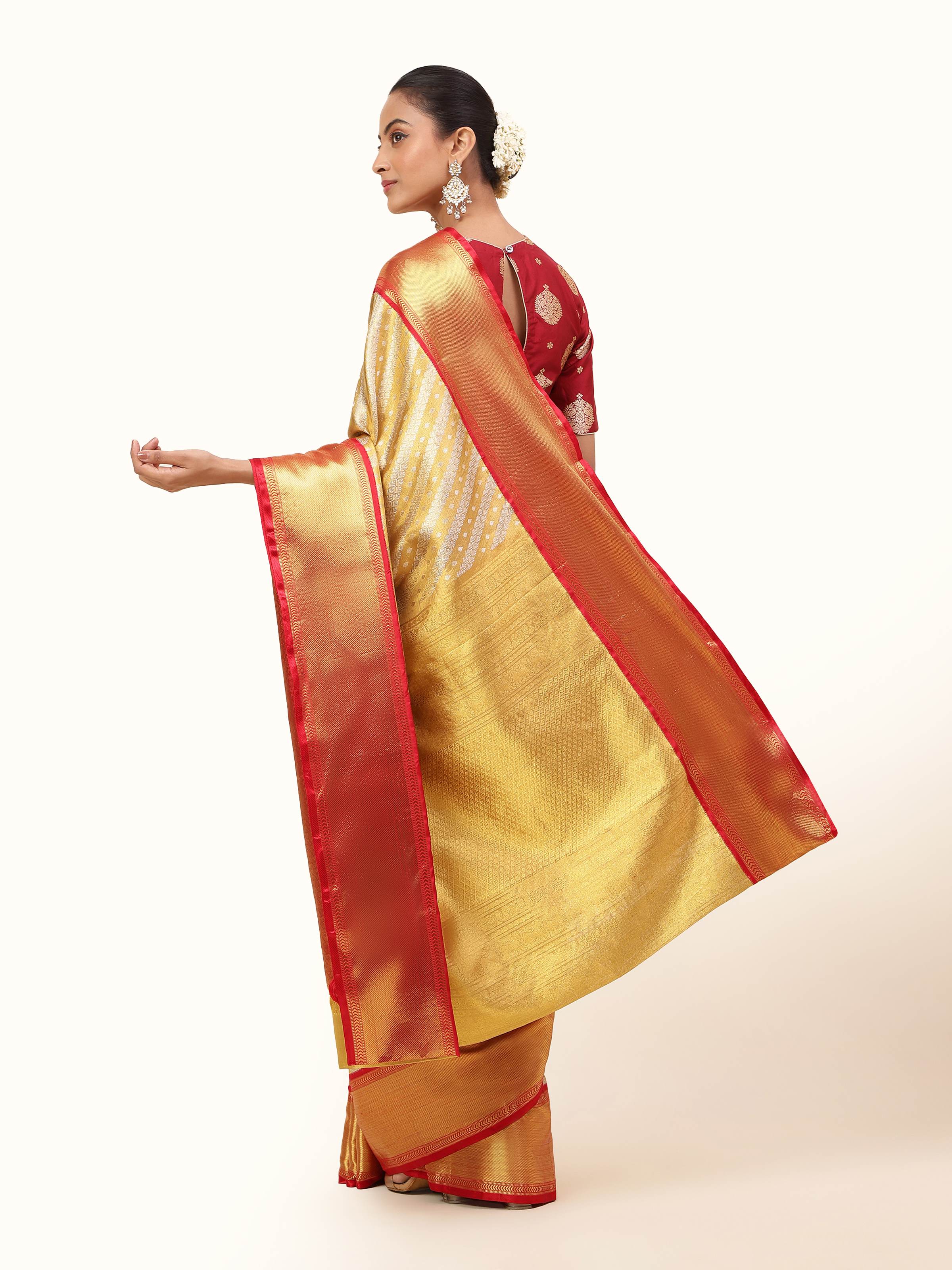 Back view of gold silk saree highlighting rich pallu and traditional border.