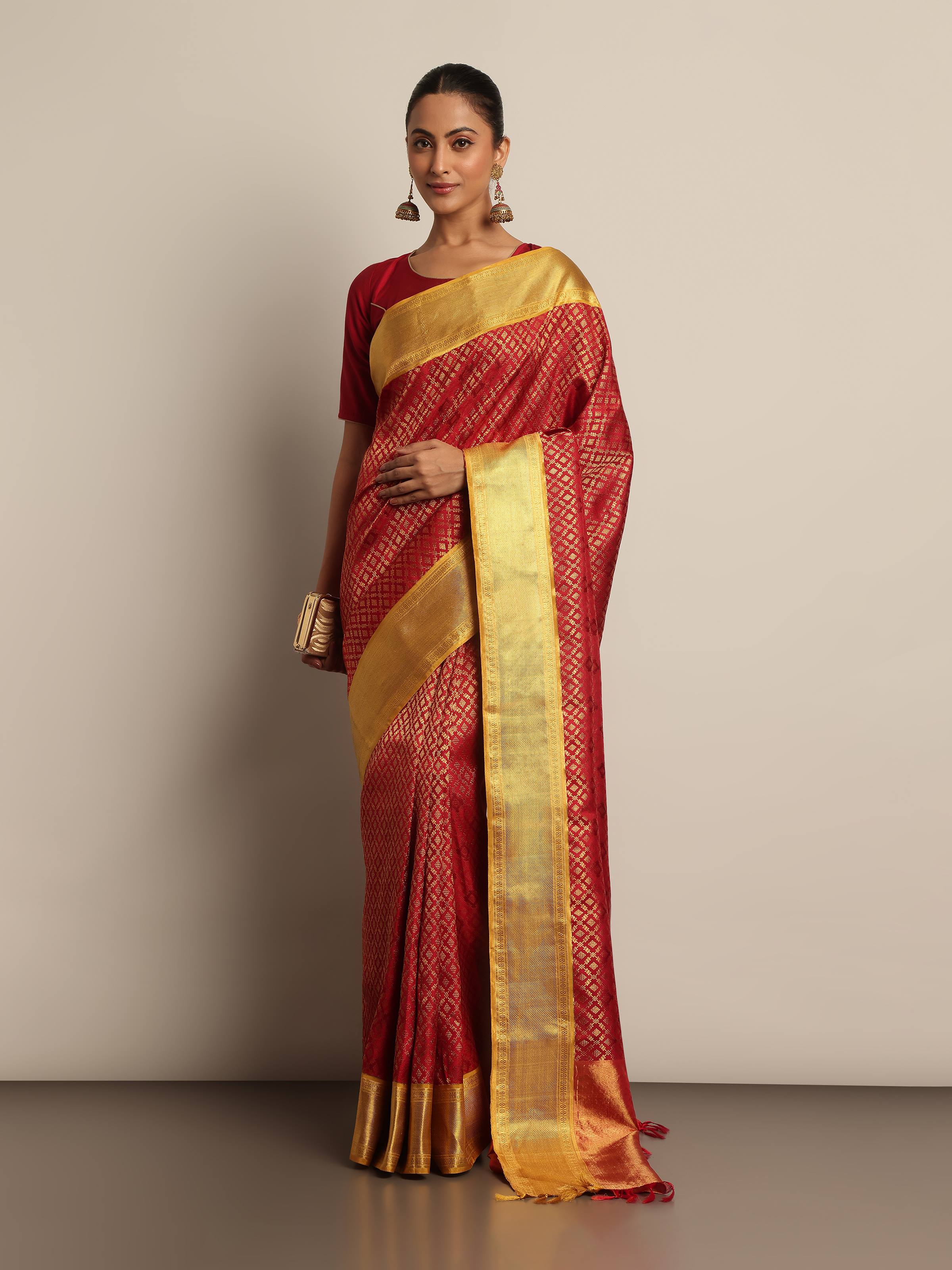 Detailed front view of model showcasing red Kancheepuram saree draped elegantly with rich zari details and classic silk texture.