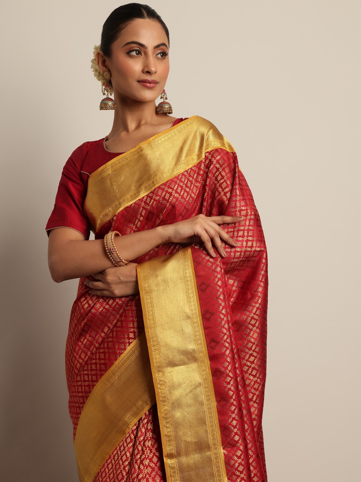 Close-up view of the red Kancheepuram silk saree highlighting its luxurious drape and ornamental pallu.