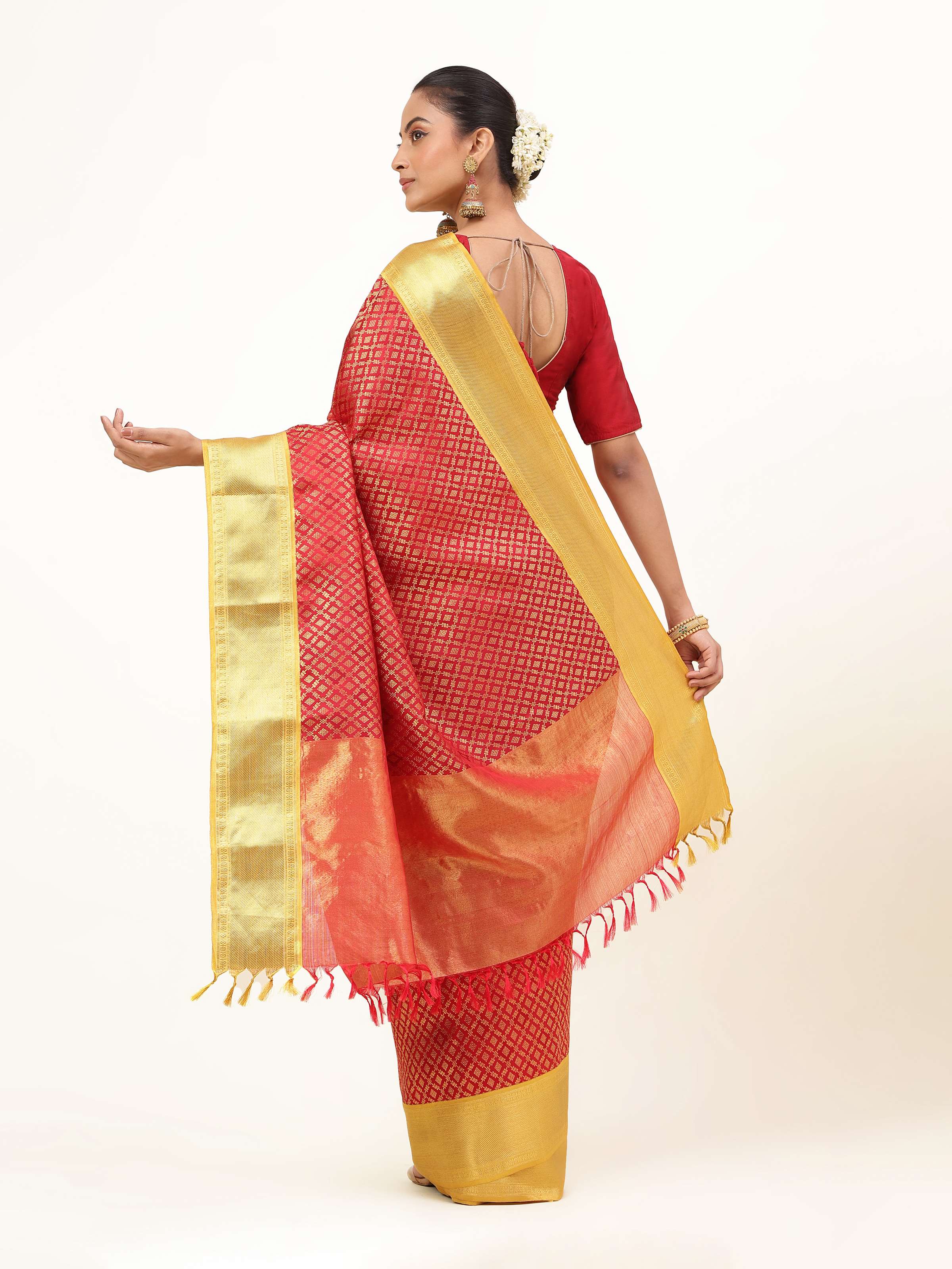 Back view of red Kancheepuram saree with shimmering golden border and traditional South Indian elegance.