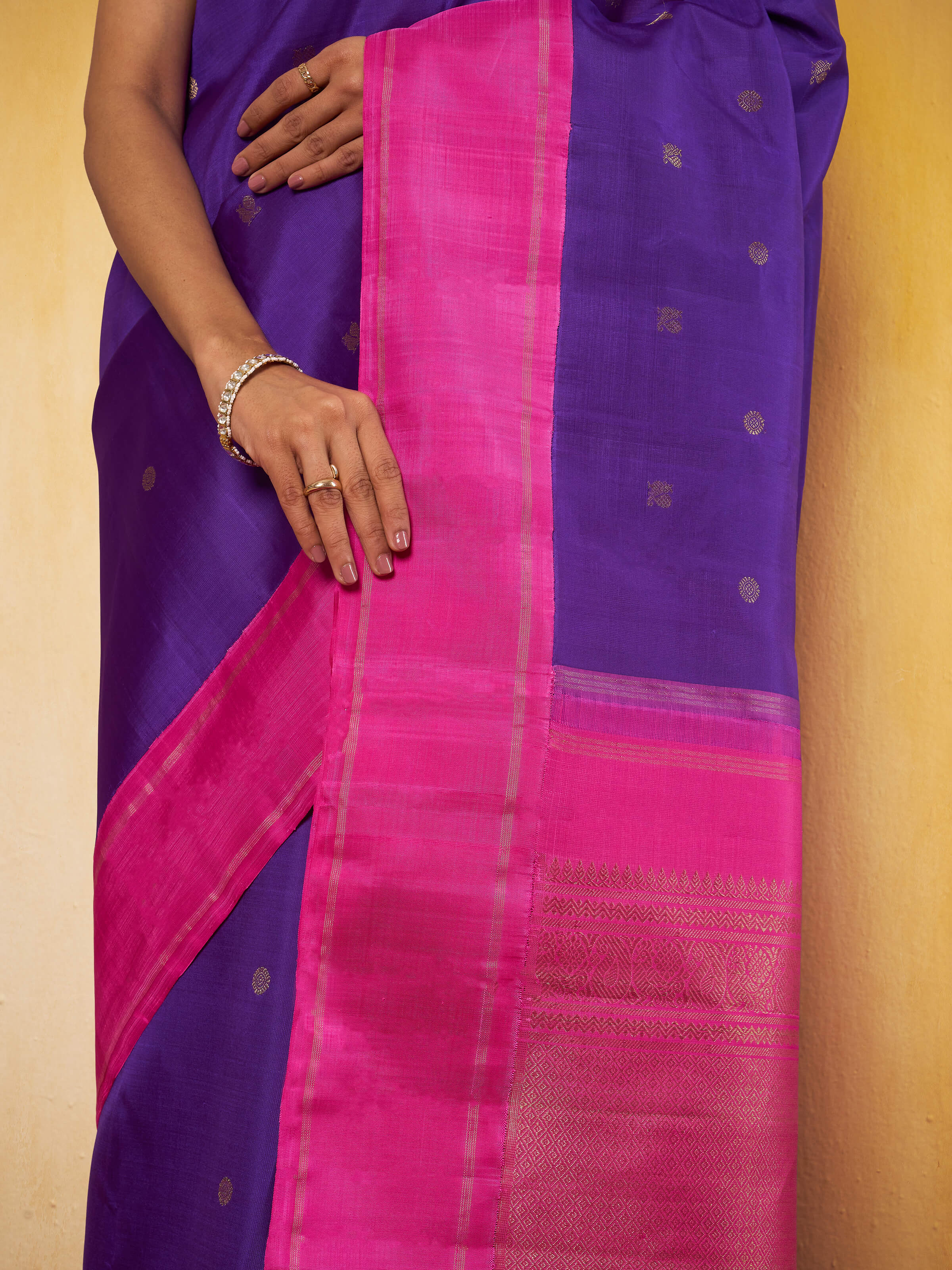 Close-up detail of silk threads and zari motifs in blue and pink Kancheepuram saree
