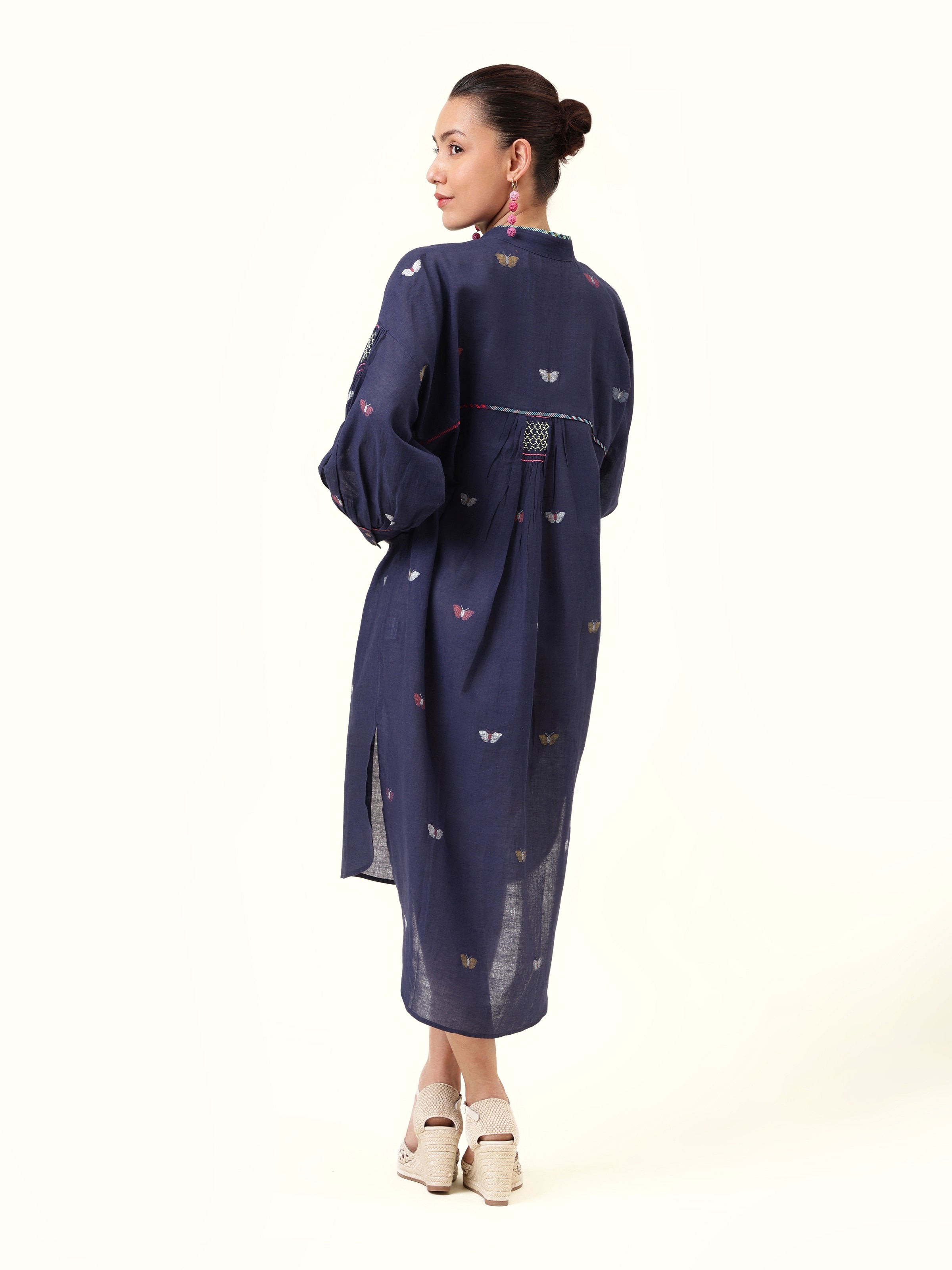 Back view focusing on the flowy cut and unique blend of traditional weaving with modern styling.