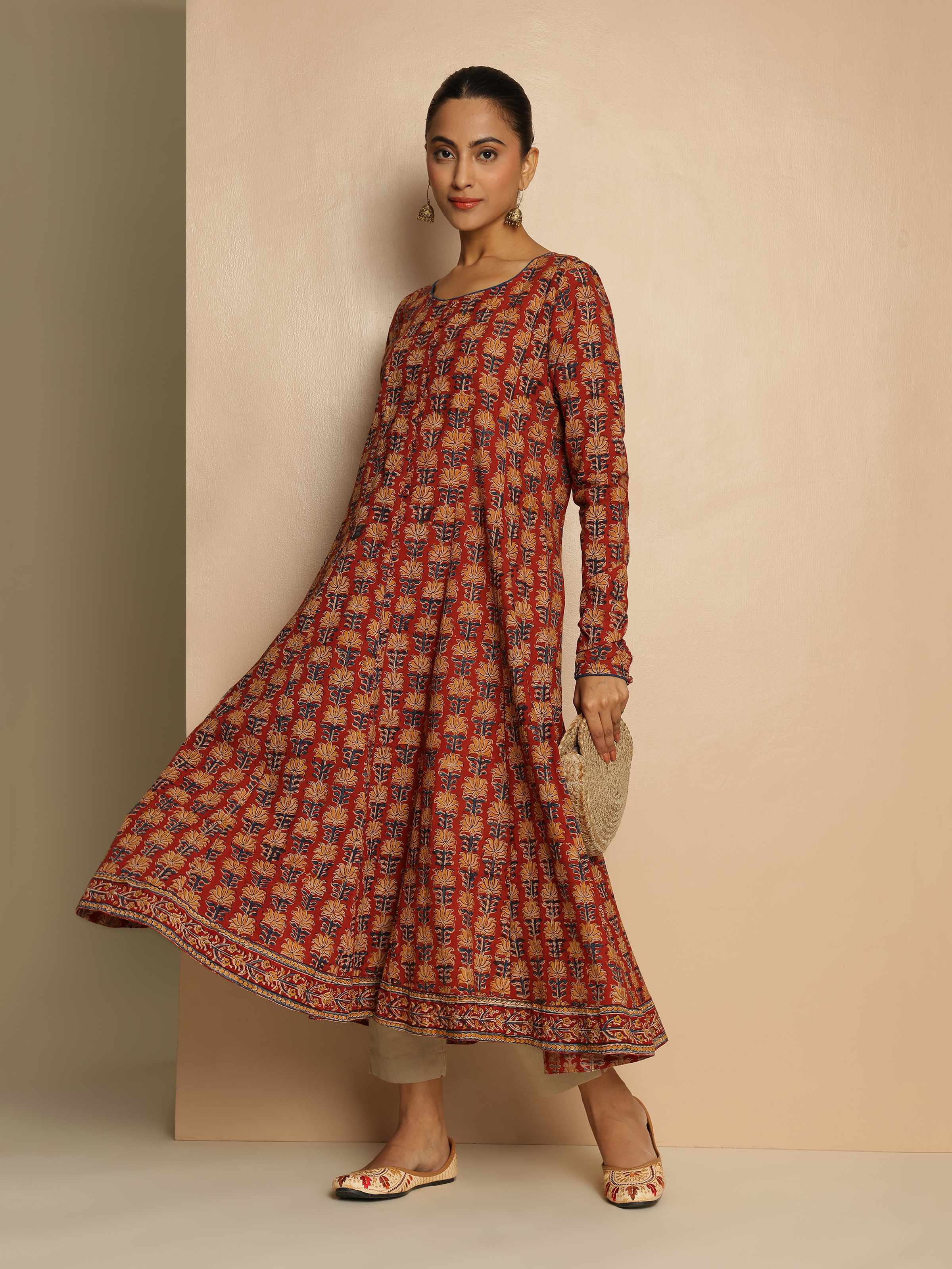 Lifestyle image of red cotton Kalamkari kurta paired with straight pants