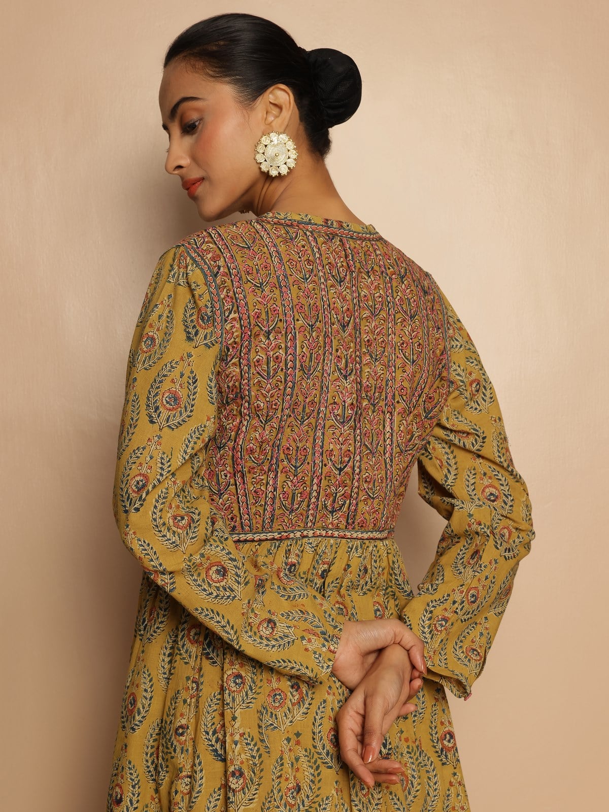 Back angled look of yellow Kalamkari cotton kurta highlighting artistic motifs and comfortable length.