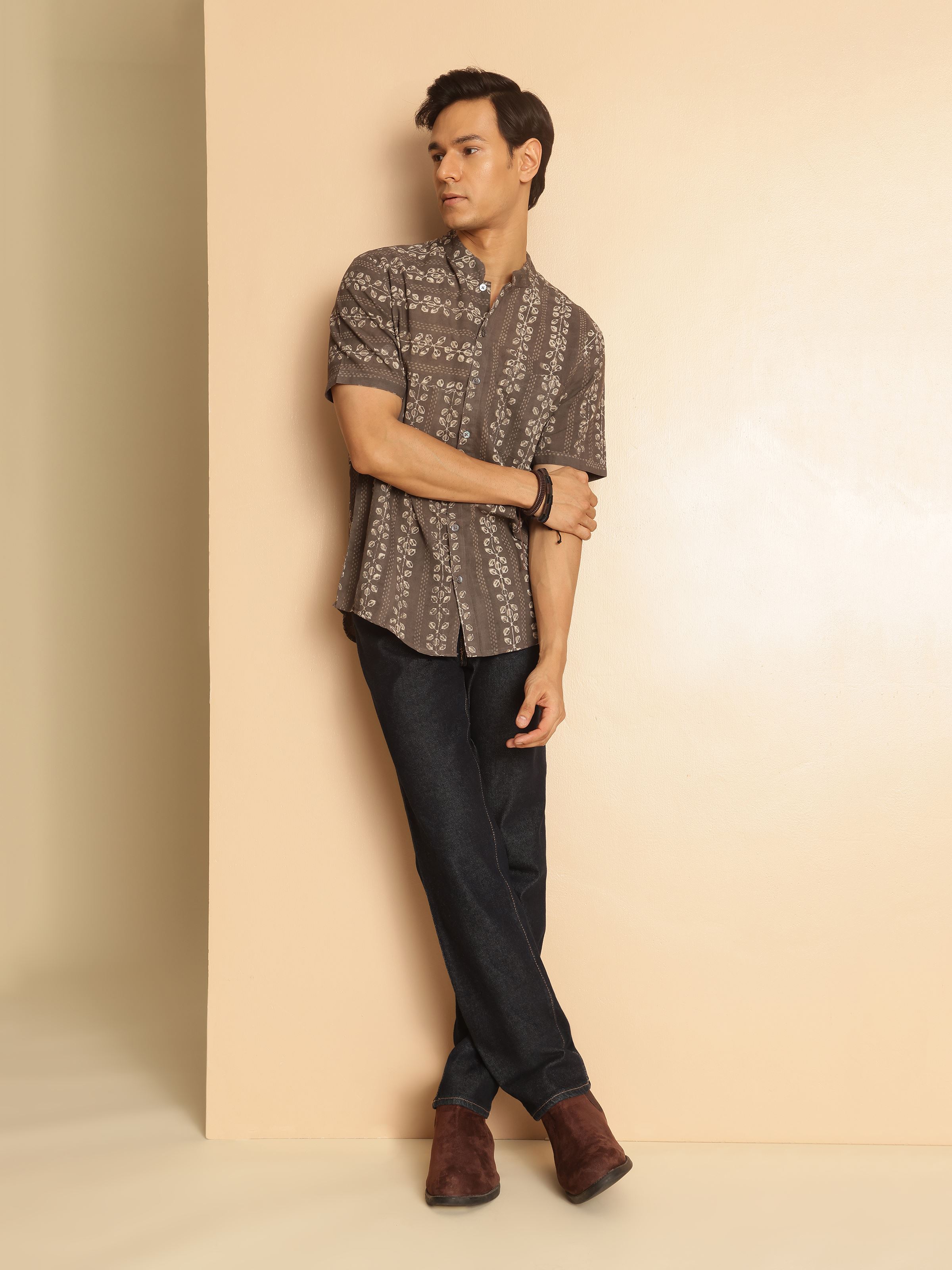 Lifestyle shot of grey cotton Dabu block printed shirt worn with jeans.