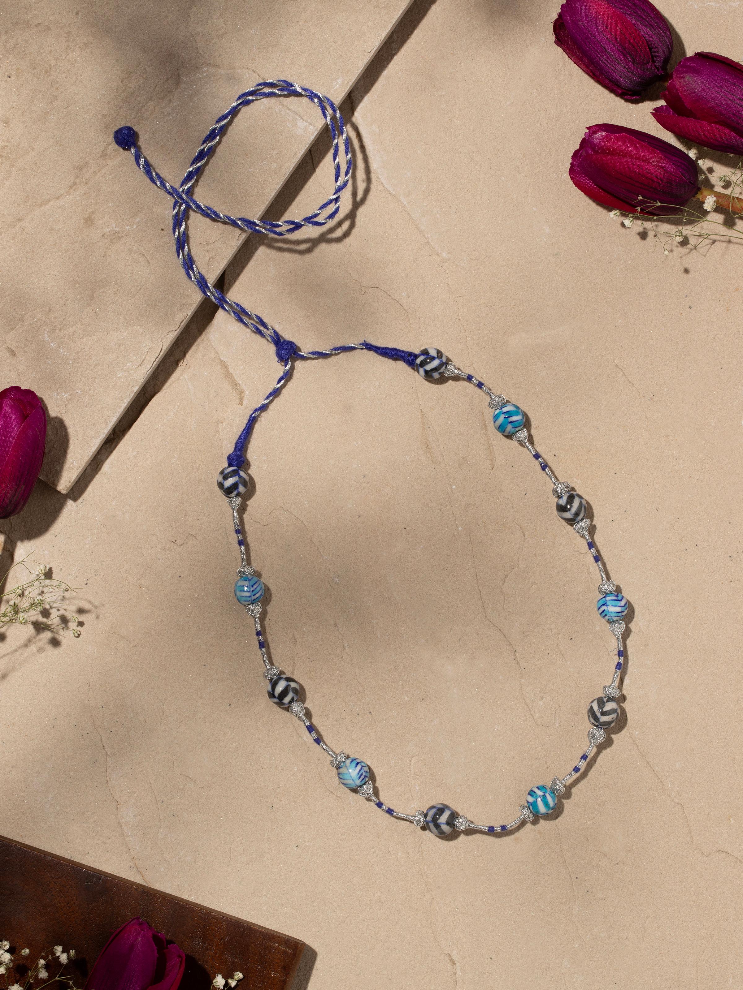 Side view of blue pottery long necklace showcasing its detailed beadwork and elegant design.