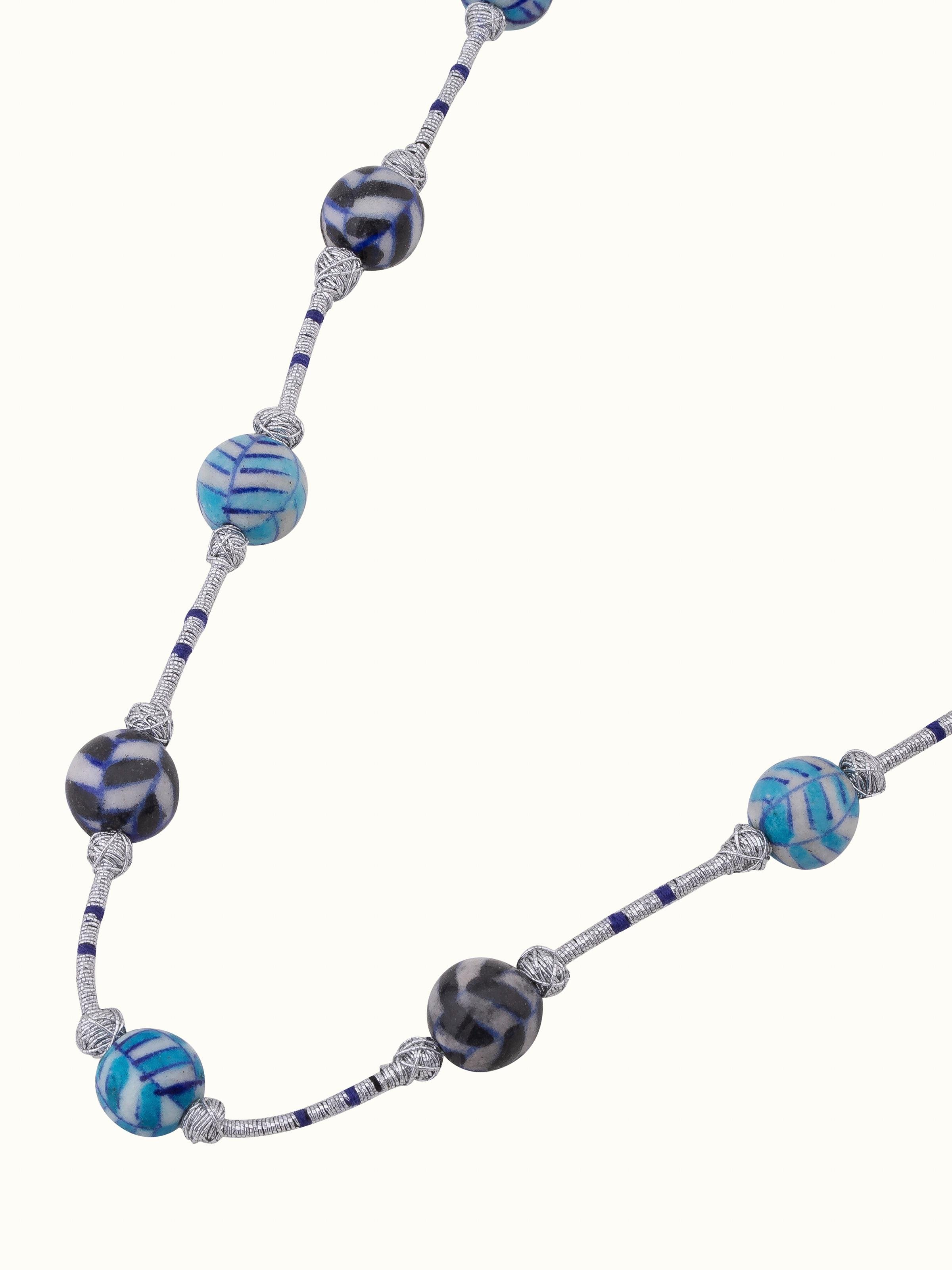 Detailed view of blue pottery long necklace focusing on the intricate pottery work and design.