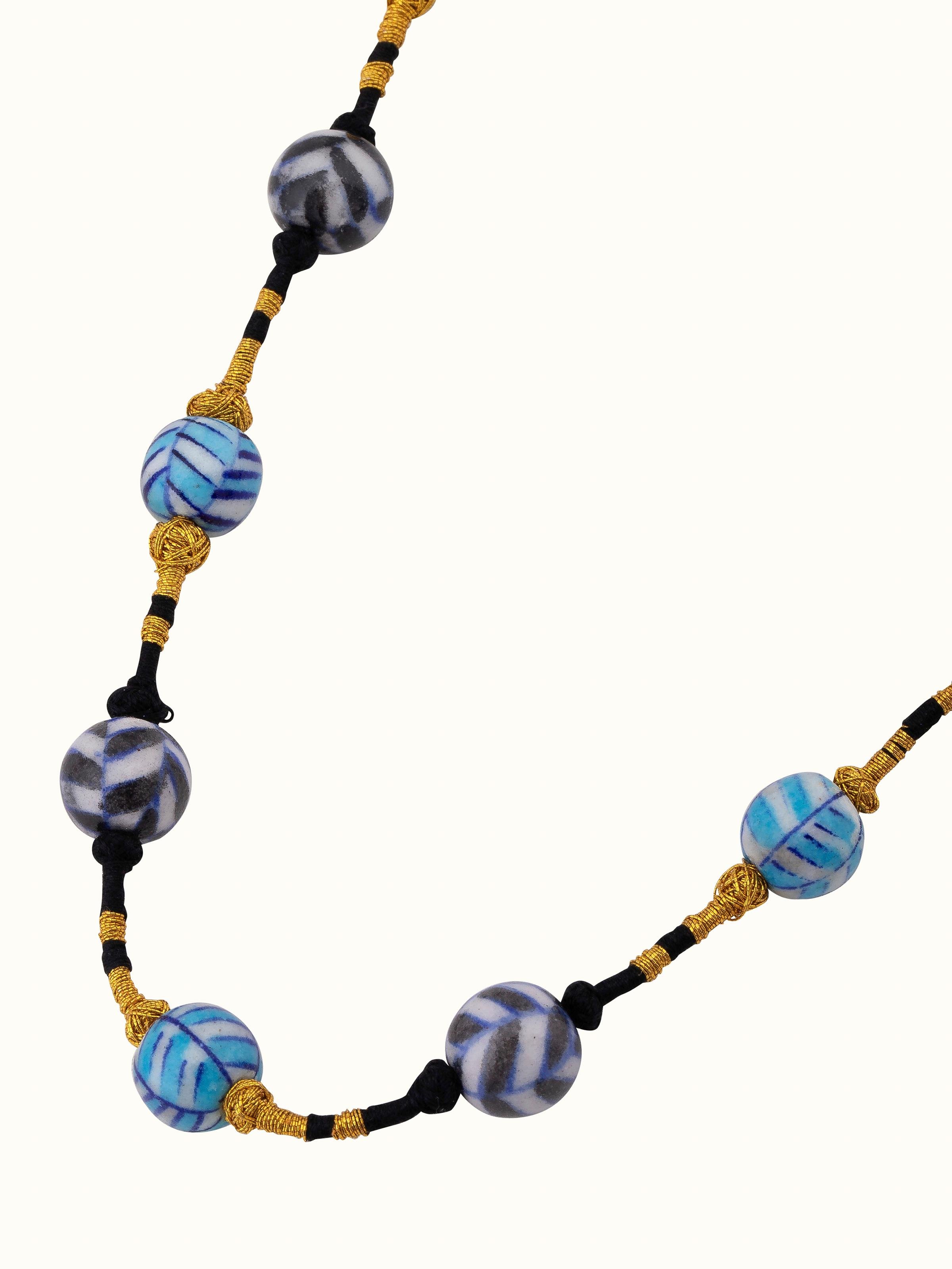 Detailed view of blue pottery long necklace emphasizing its unique design and intricate details.