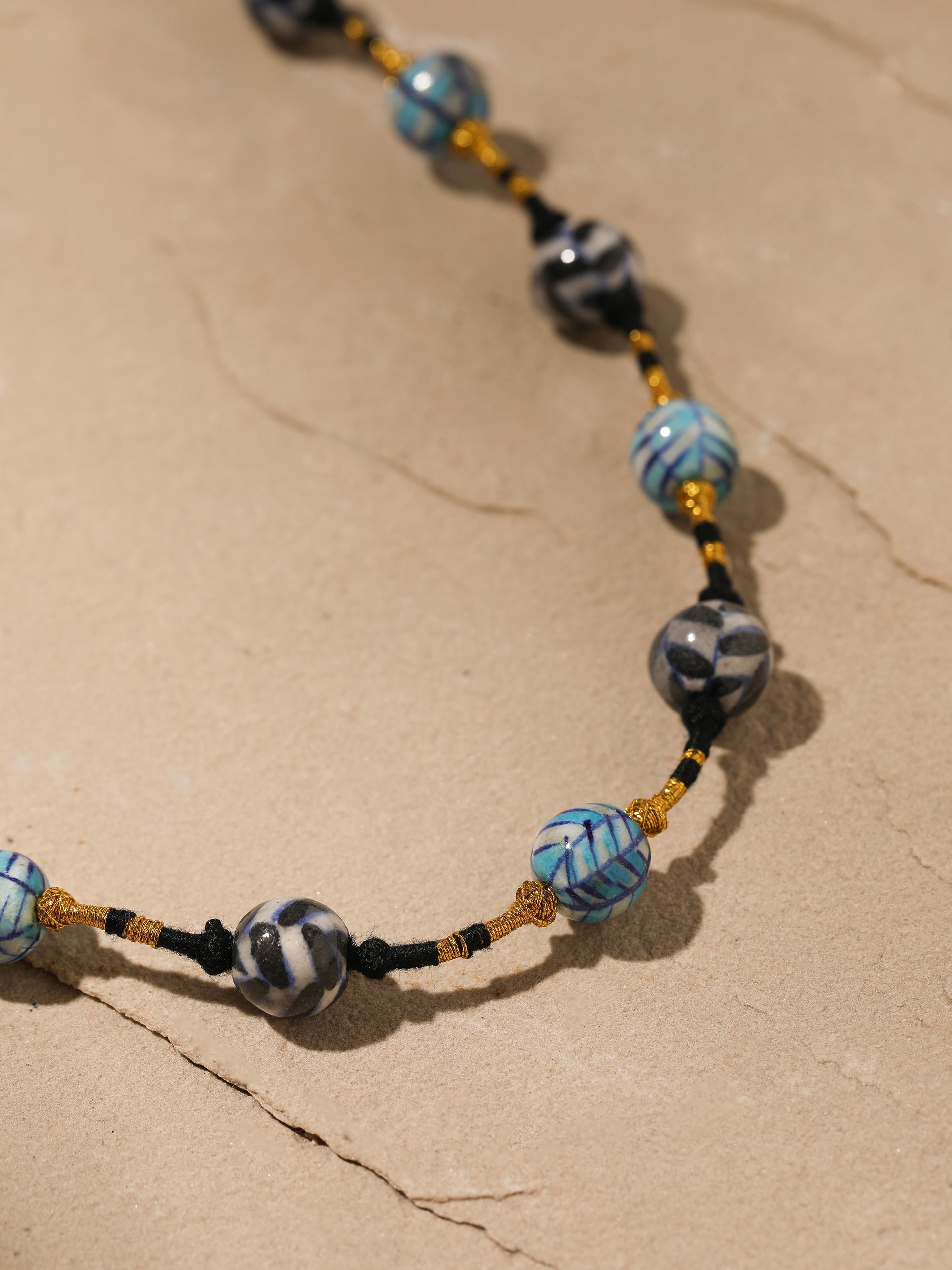 Back view of blue pottery long necklace showing the clasp and overall design.