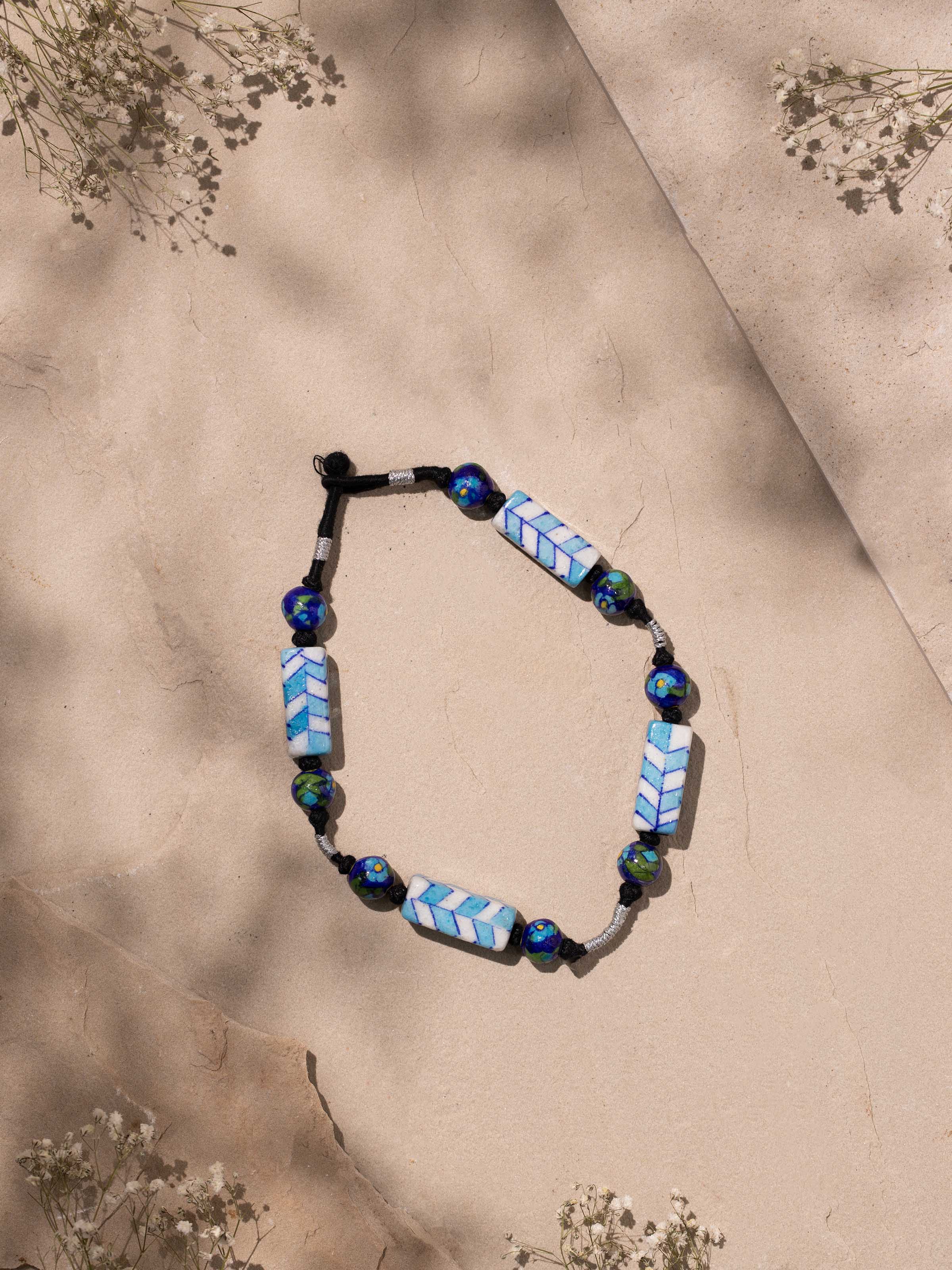 Side view of Blue Pottery Long Necklace highlighting the unique pottery beads and elegant chain.