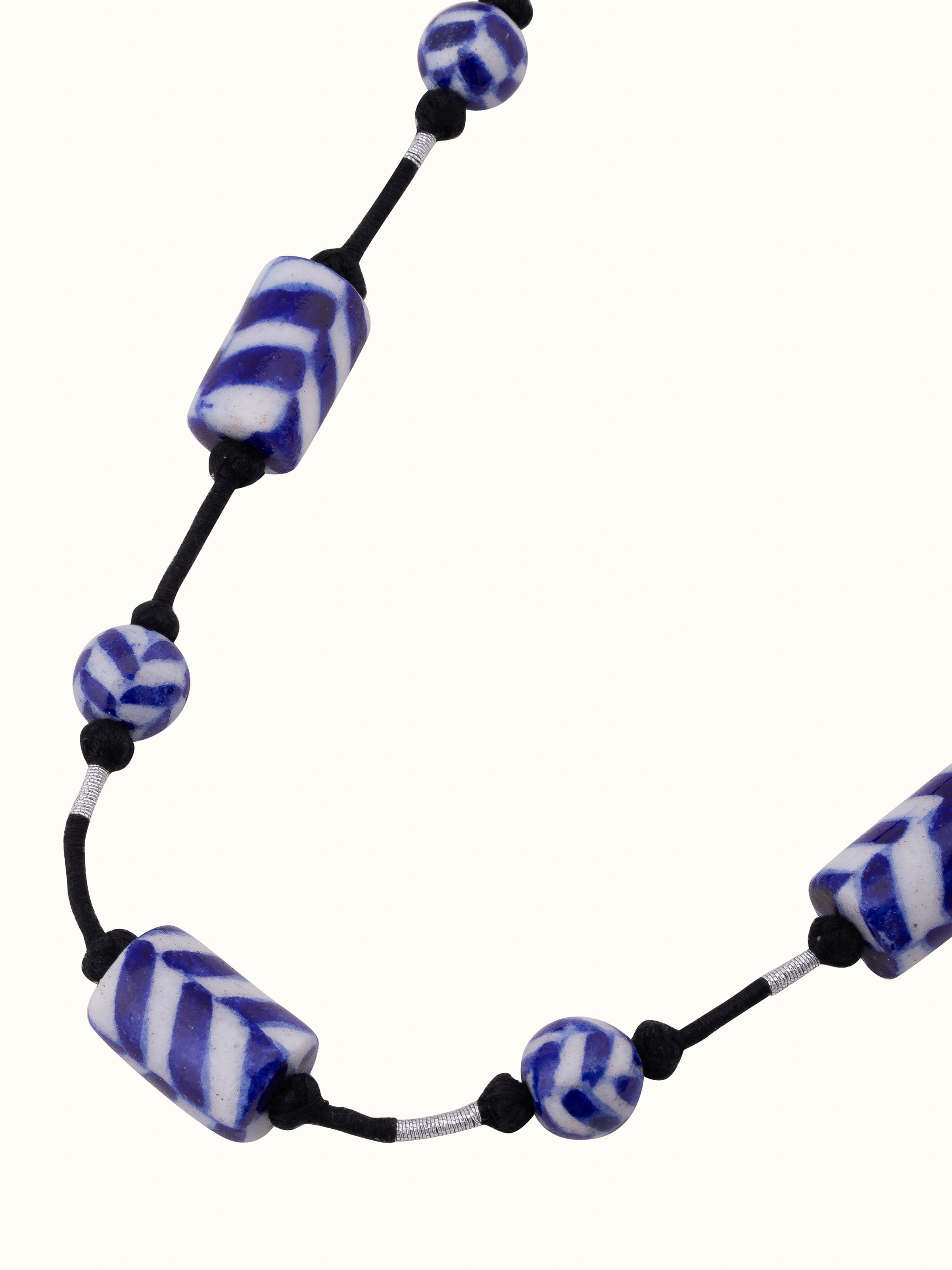 Overhead view of blue pottery long necklace showing its full length and detailed design.