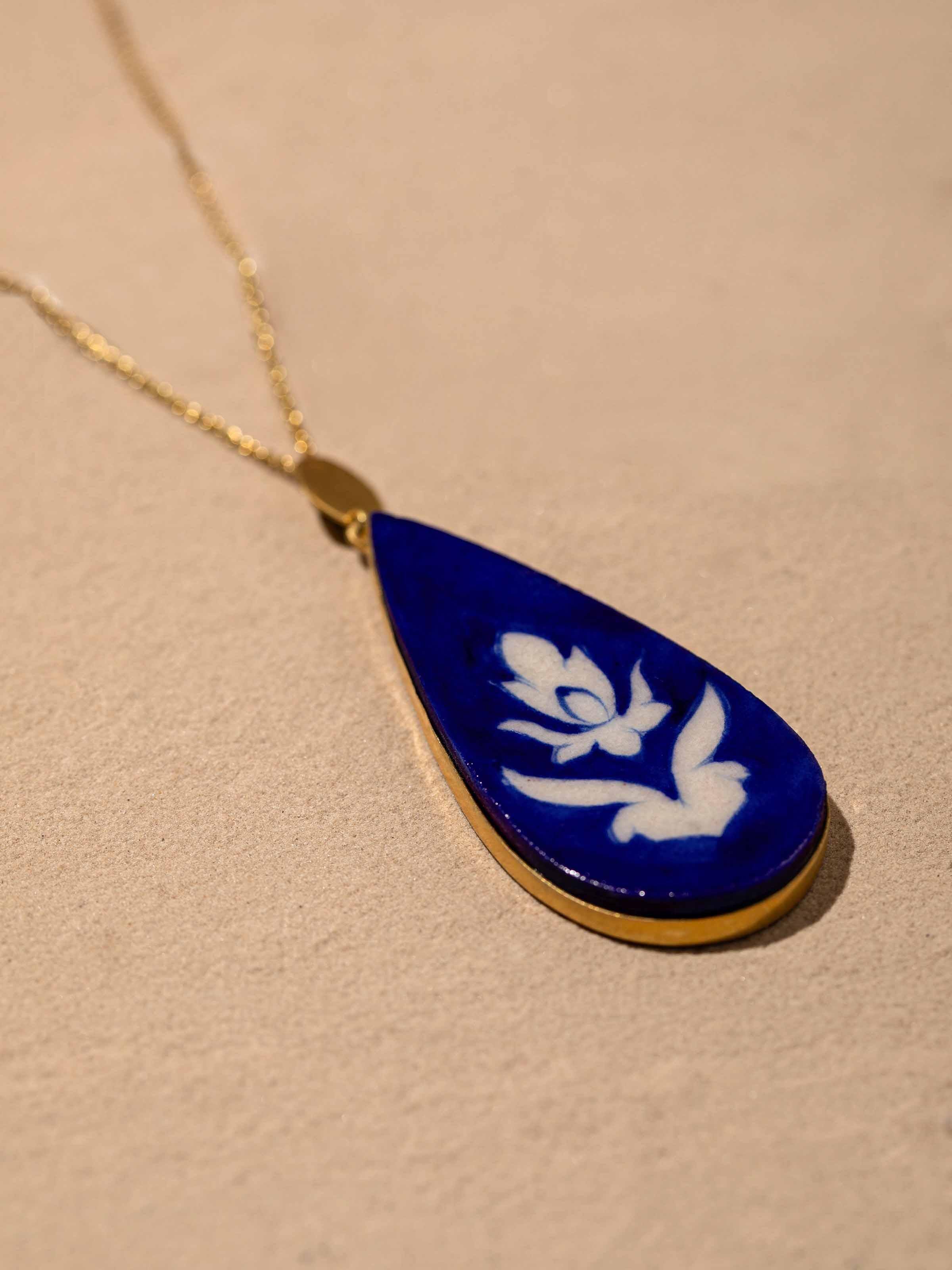 Overhead view of Blue Pottery Pendant & Chain featuring vibrant blue pottery and detailed chain design.