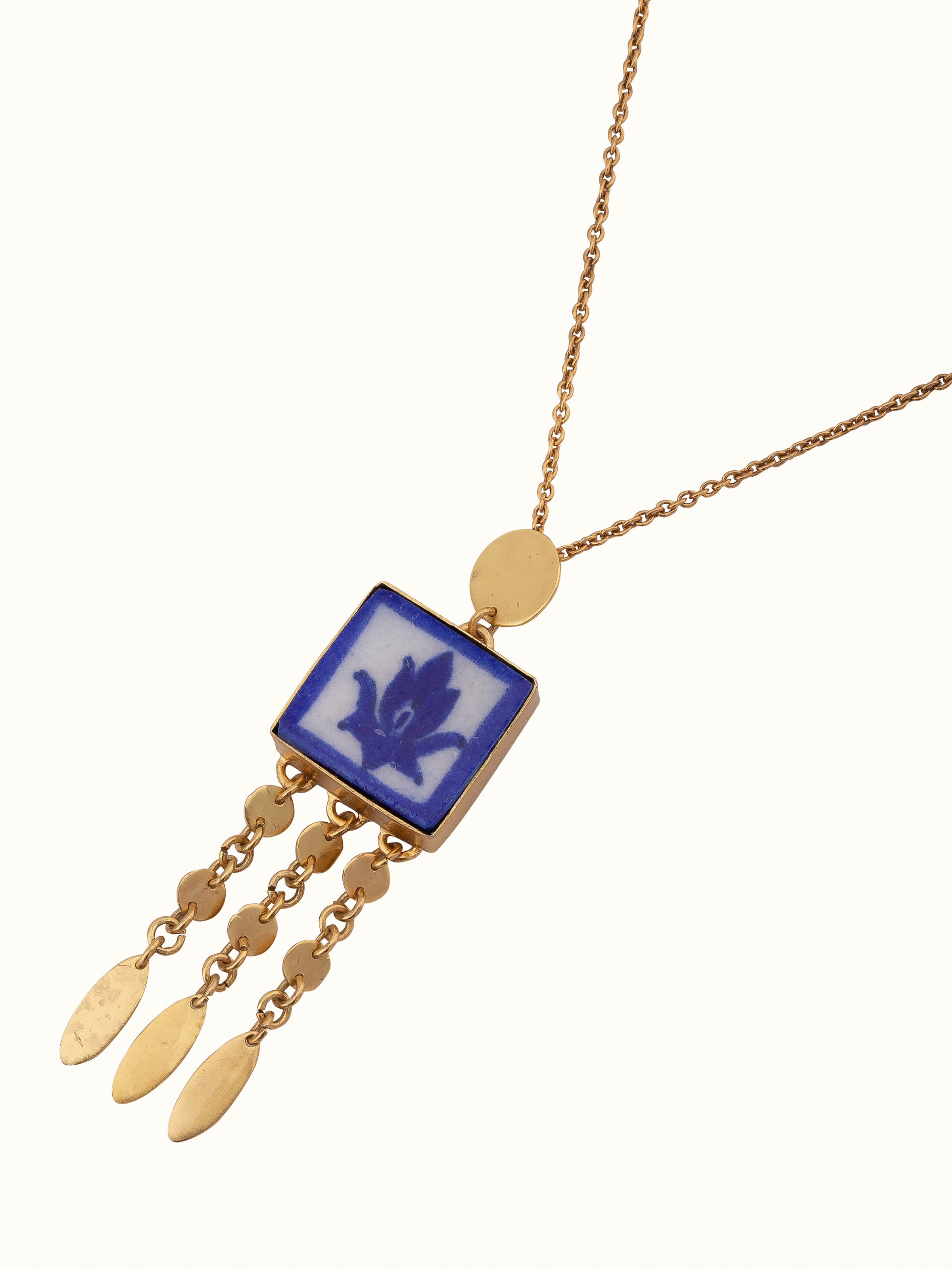 Angled view of blue pottery pendant & chain showcasing the pendant’s design.