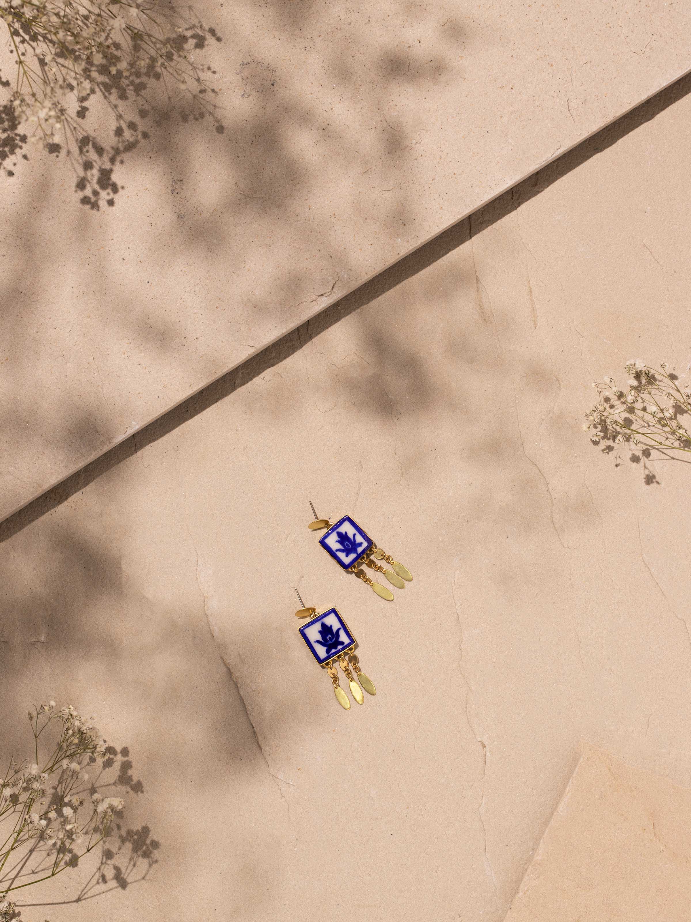 Side view of blue pottery drop earrings showcasing their unique design and artistic details.