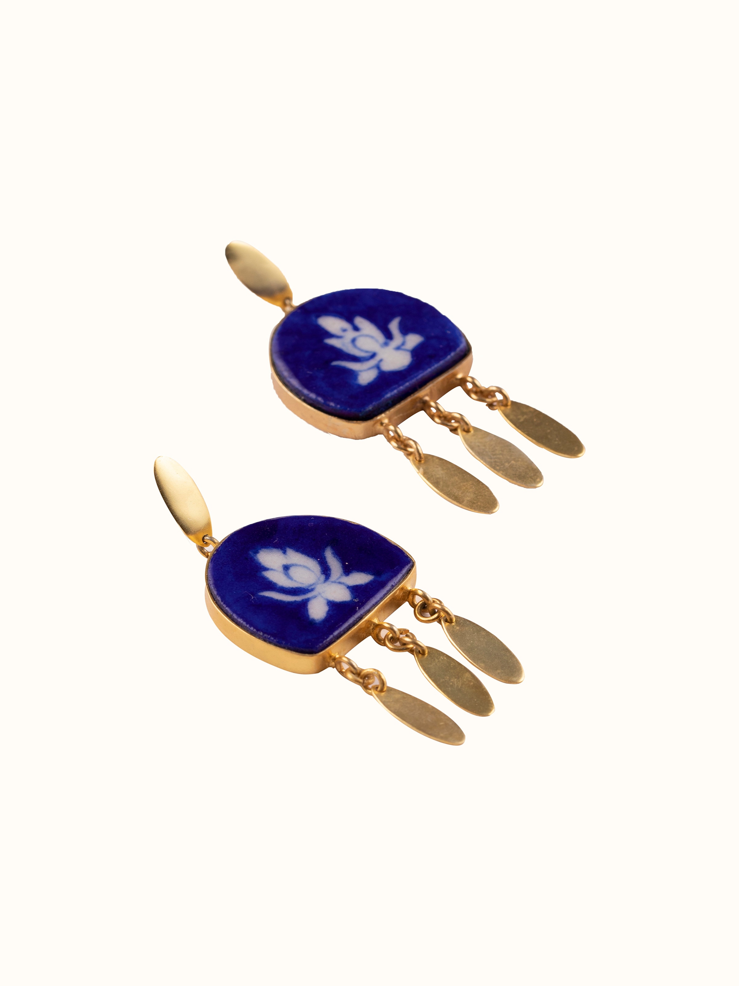 Overhead view of blue pottery drop earrings showing their complete design and hanging style.