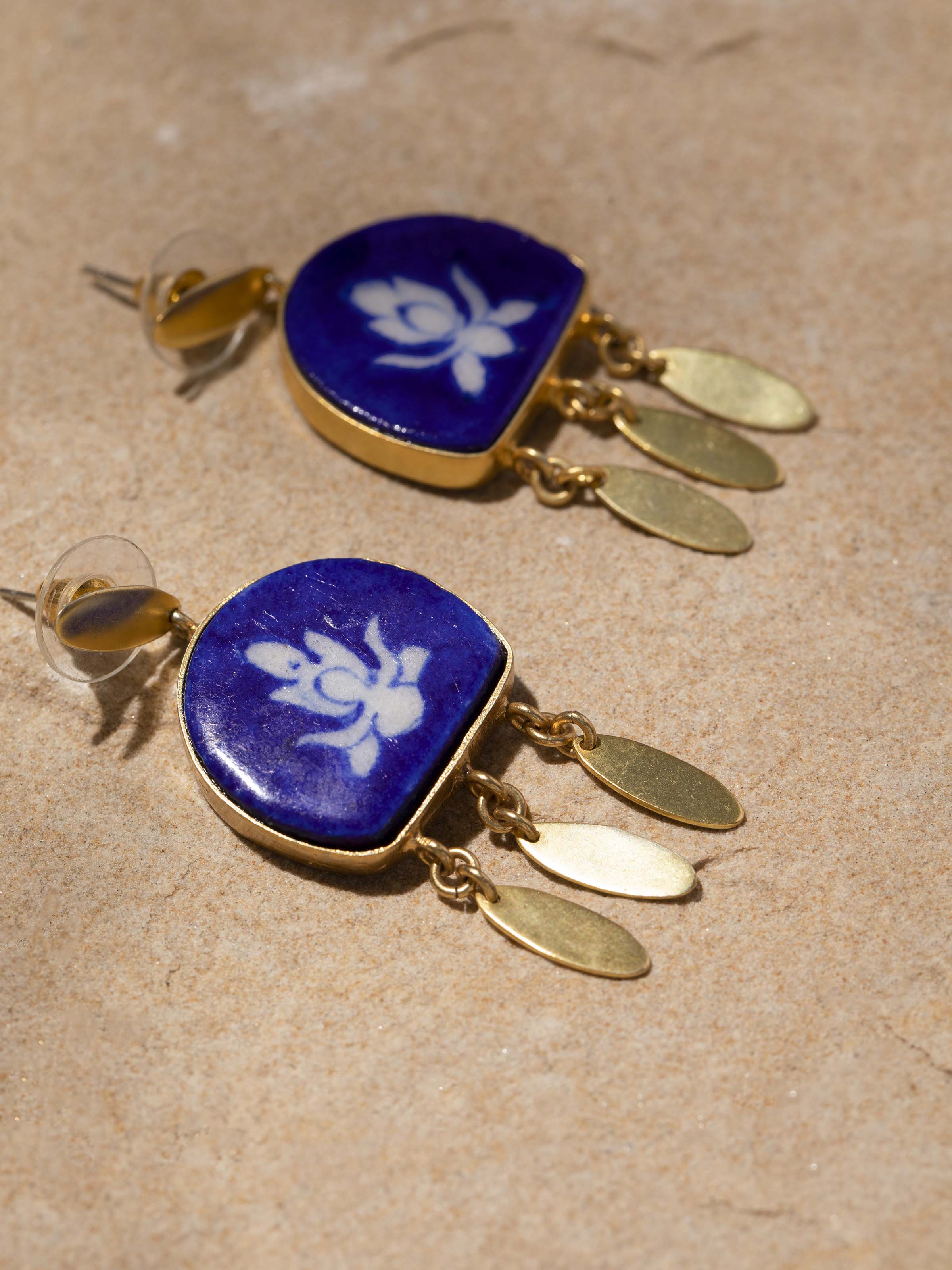 Detailed close-up of blue pottery drop earrings emphasizing the texture and intricate designs.