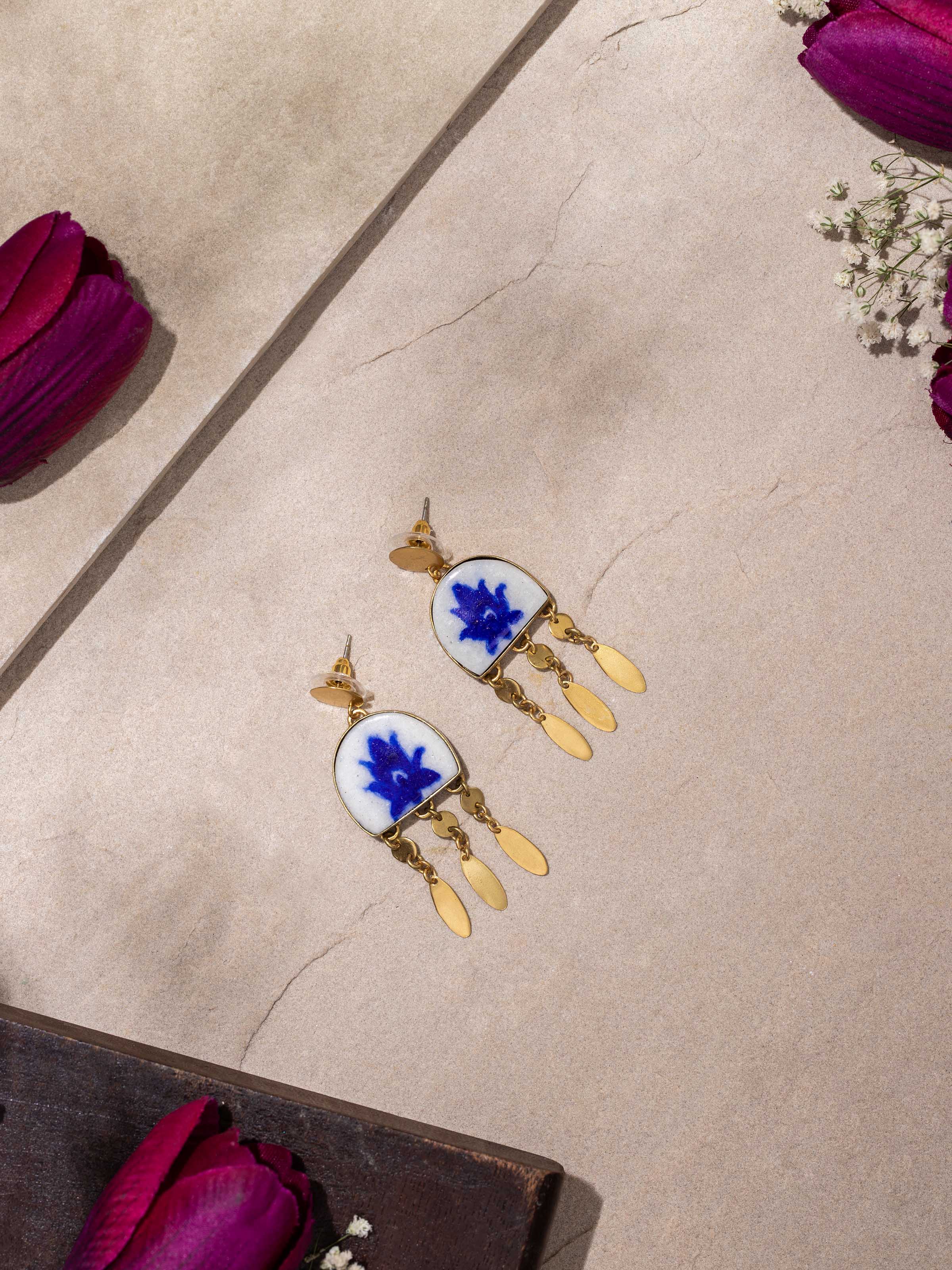 Close-up view of blue pottery drop earrings emphasizing the intricate pottery work and colors.