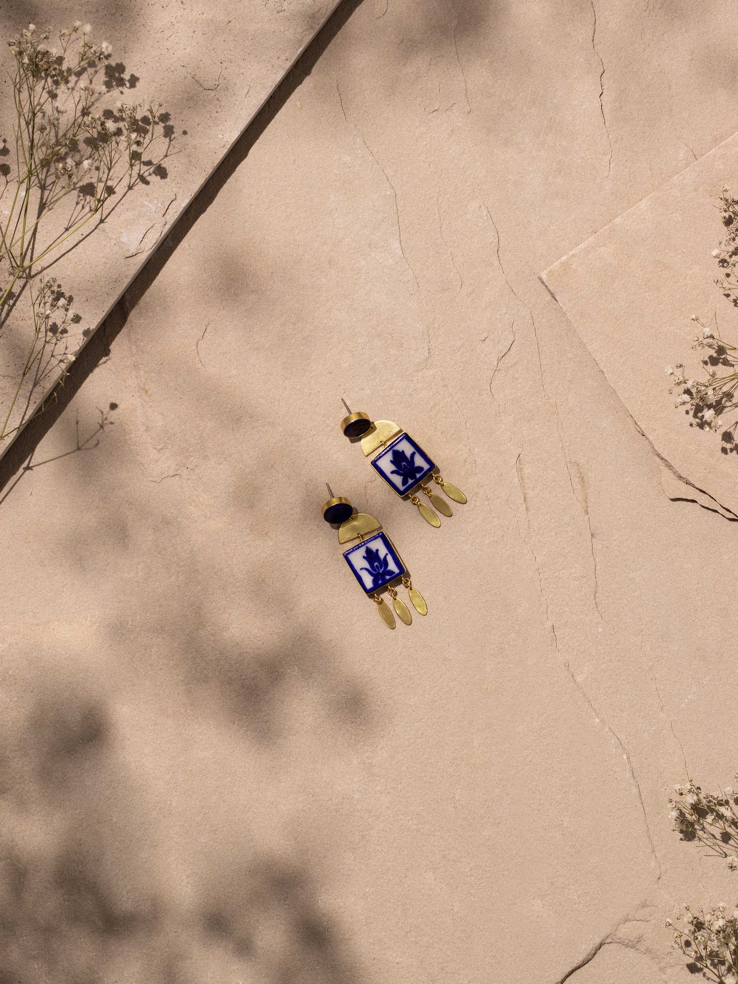 Side view of blue pottery drop earrings showcasing their unique shape and design
