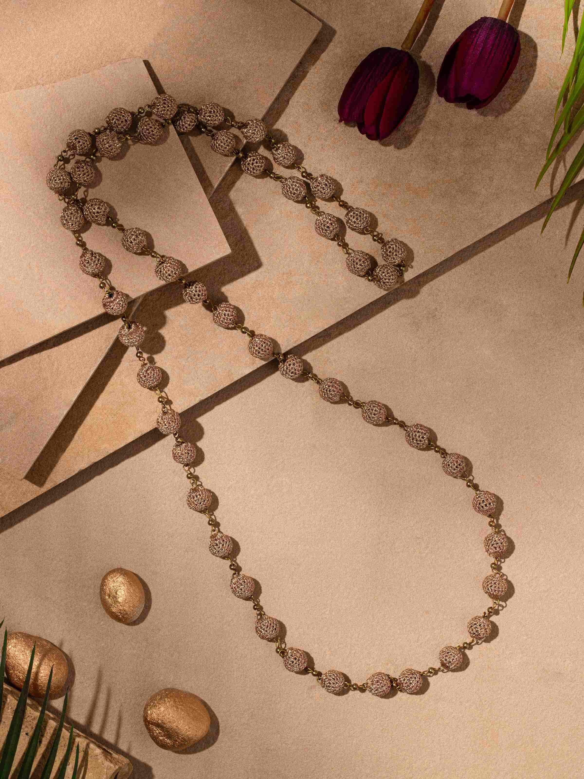 Side view of crochet long necklace emphasizing the detailed crochet pattern and its elegant drape.