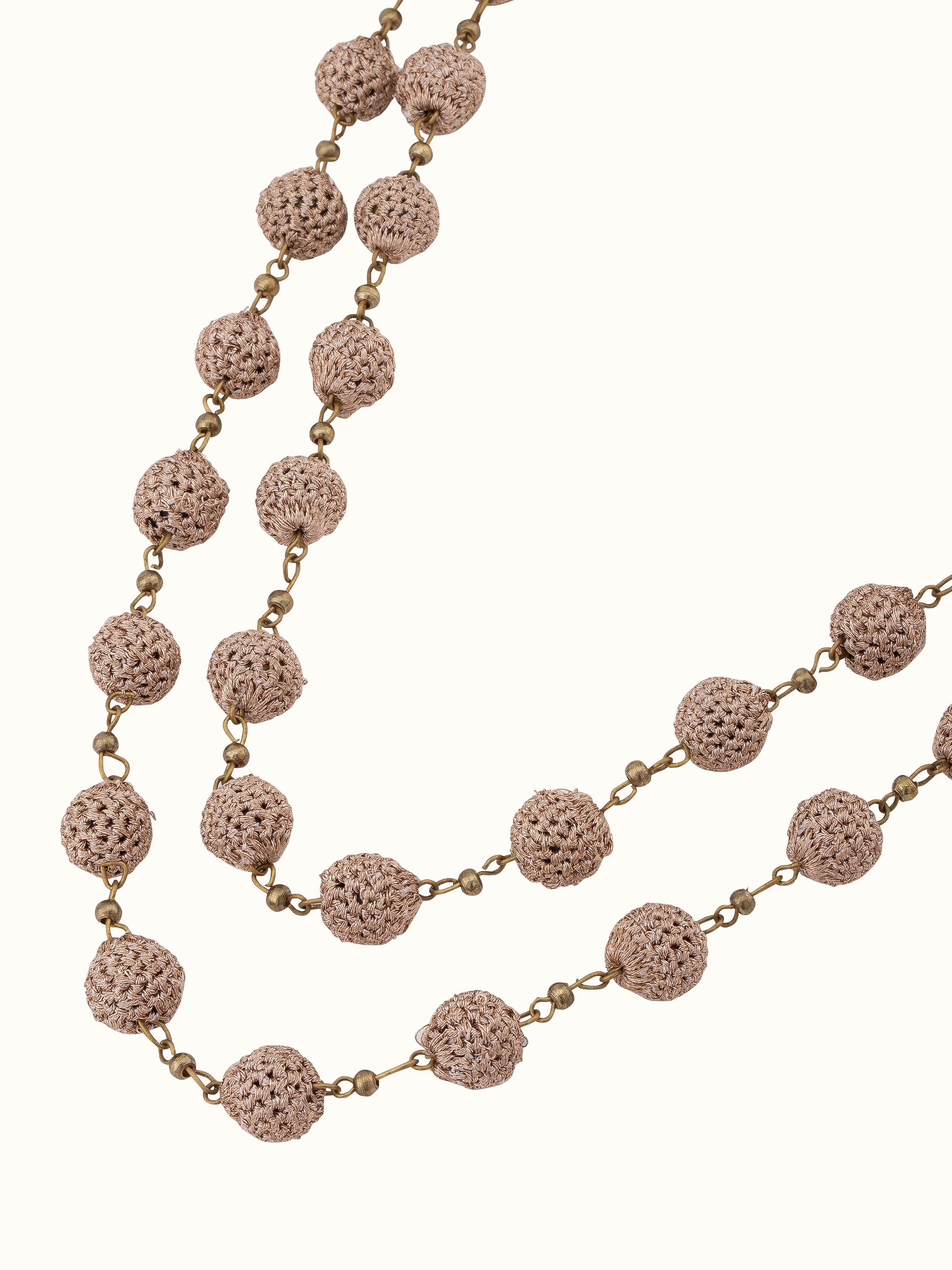 Crochet long necklace displayed in a box, showcasing its elegant presentation and detailed design.