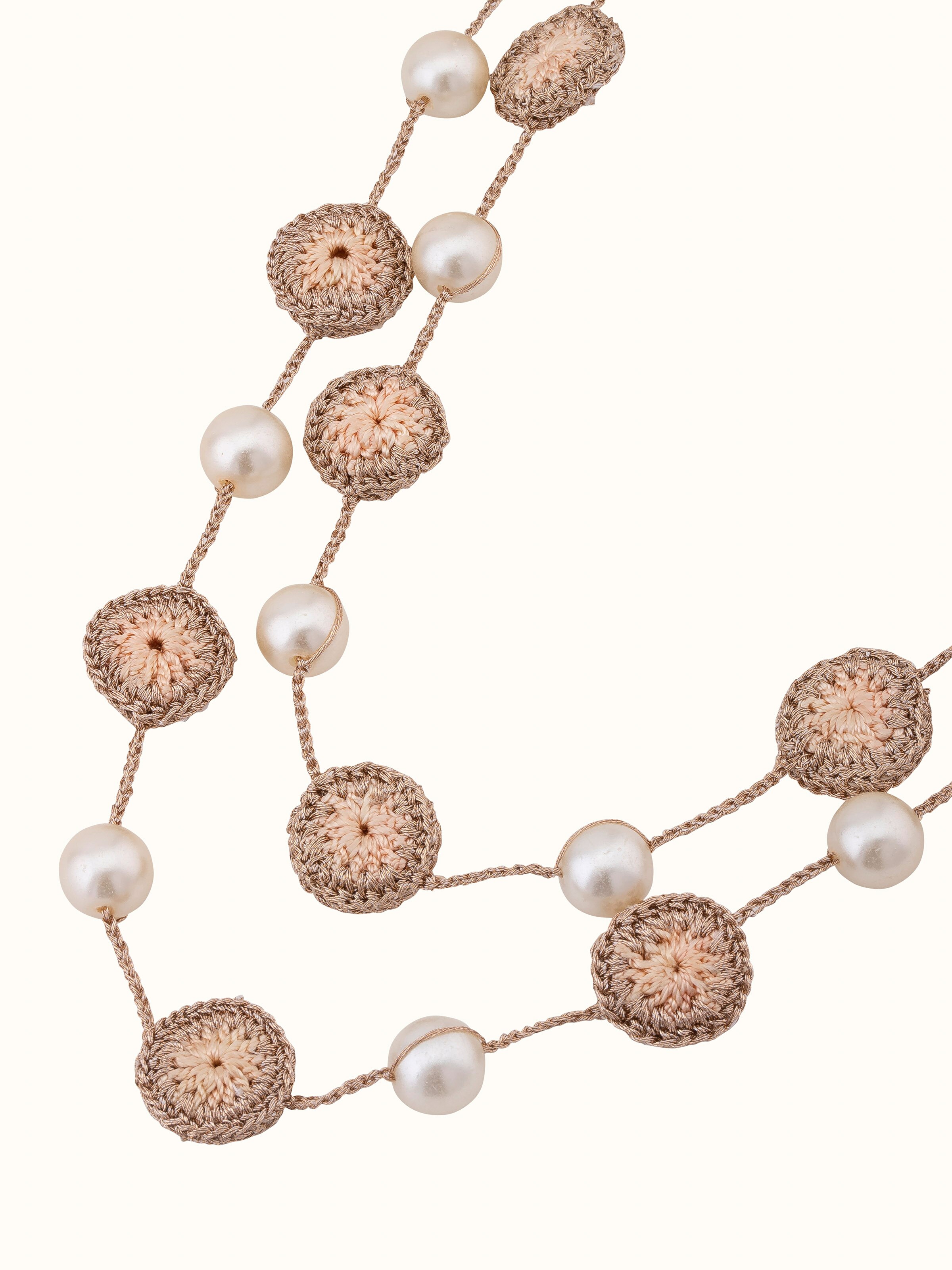 Angled view of crochet long necklace showcasing unique crochet elements and texture