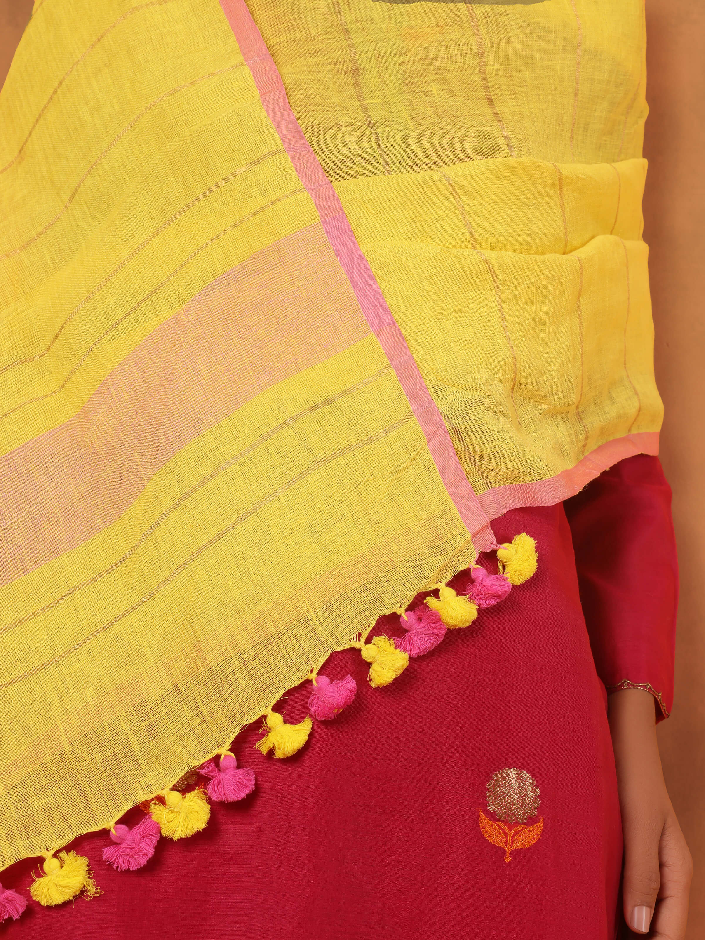 Detail shot of yellow linen dupatta focusing on tasseled border and woven linen grain