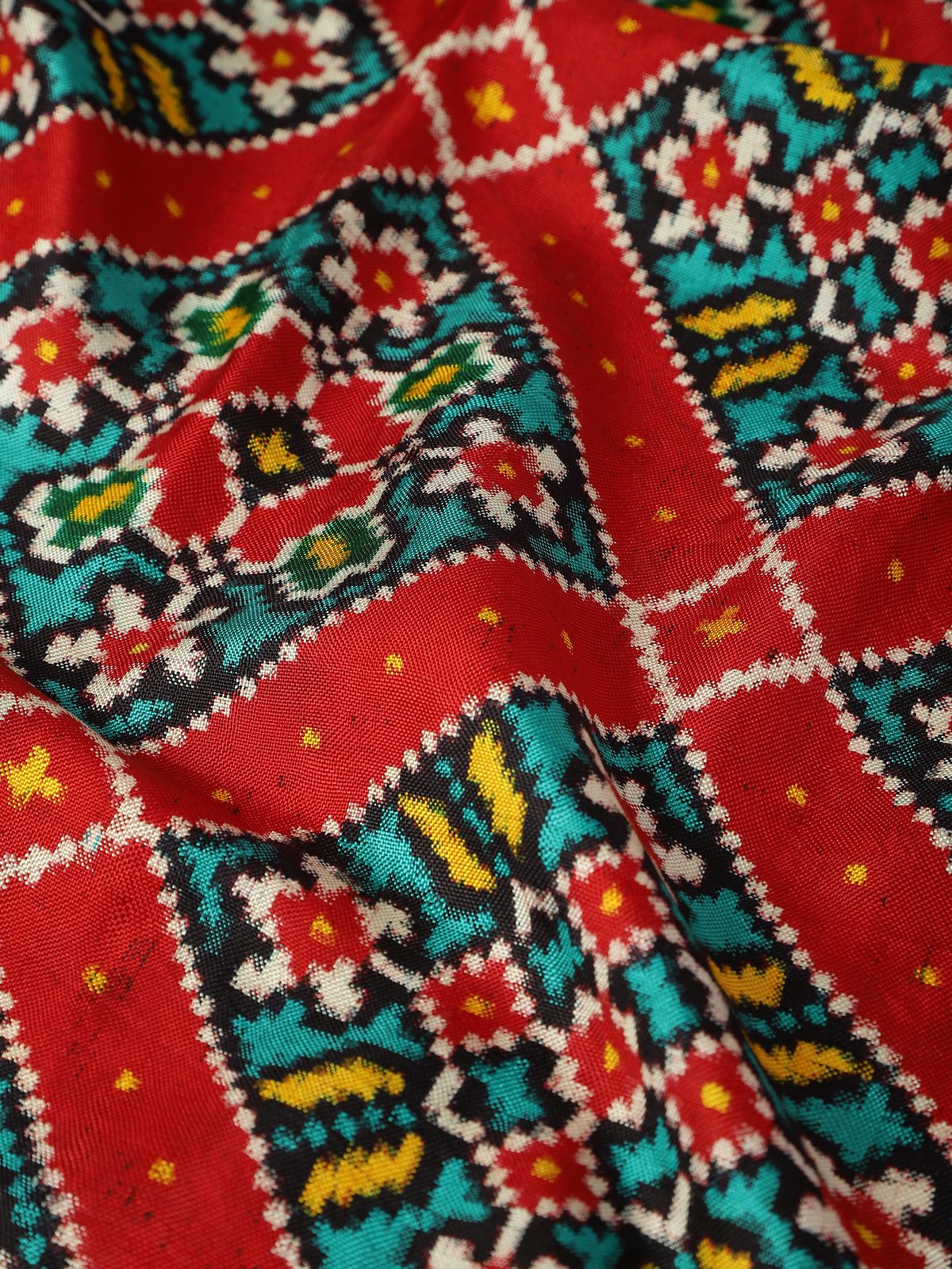 Detail view of red silk Patola dupatta capturing woven design and silk sheen