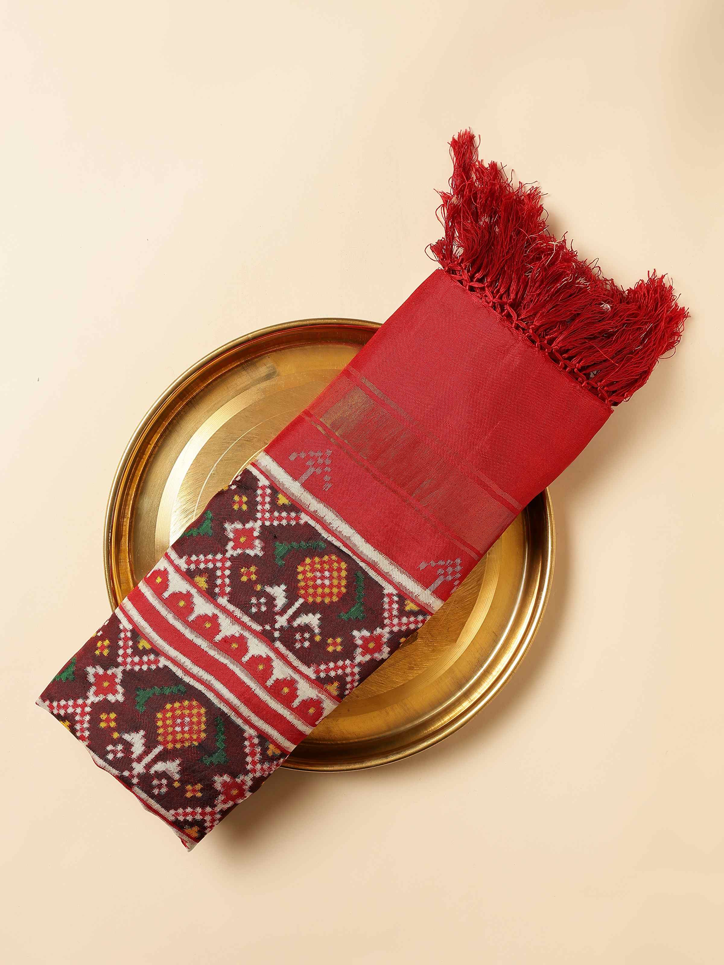 Close-up view of red Patola silk dupatta highlighting borders and intricate patterns