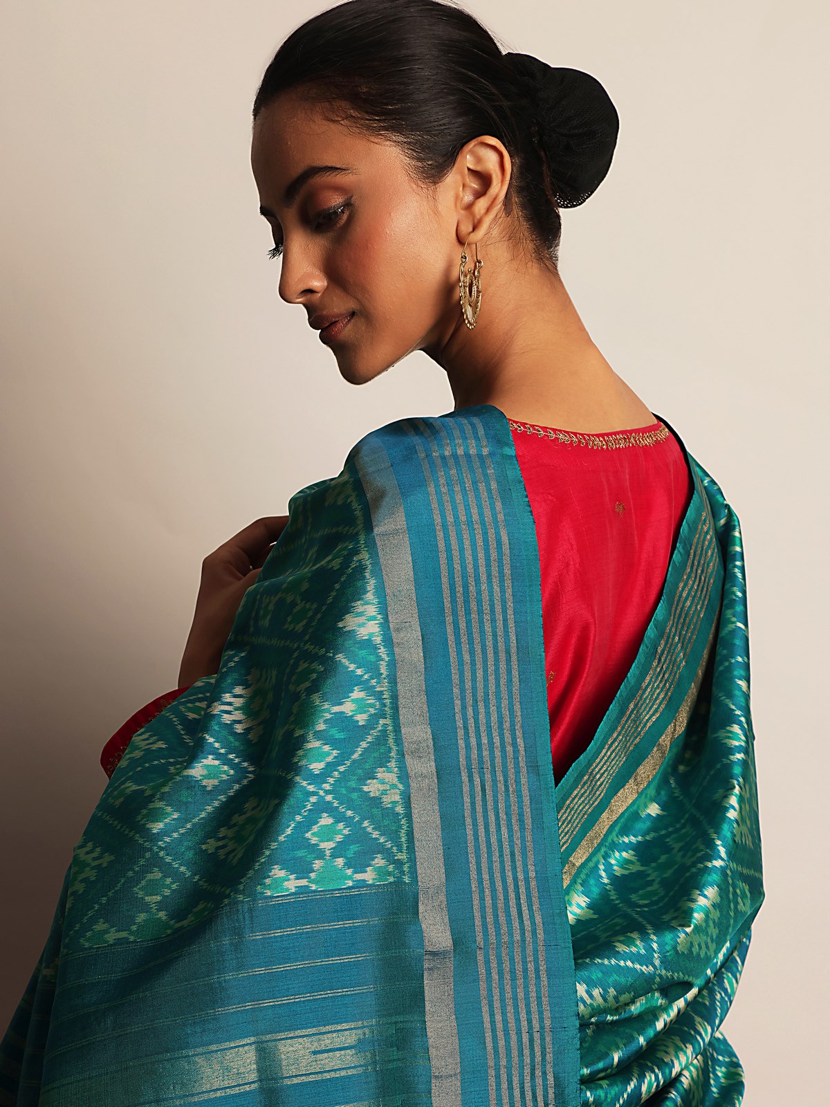 Angled lifestyle view of silk Ikat dupatta in blue and gold with handwoven texture and zari shine