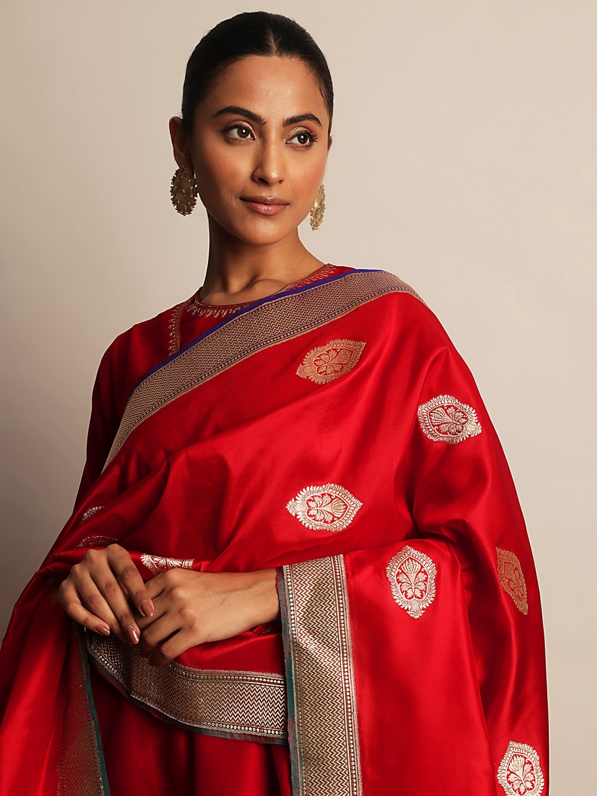 Angled shot highlighting rich gold zari motifs on red silk Banarasi dupatta