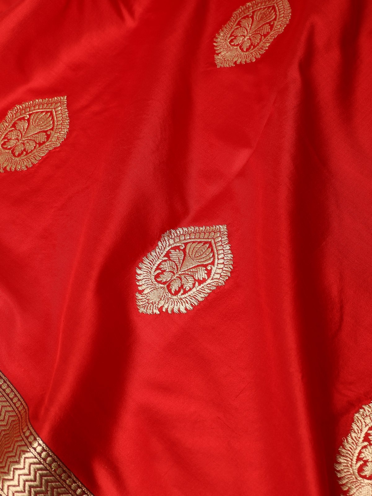 Detail view of intricate gold zari patterns on red silk Banarasi dupatta