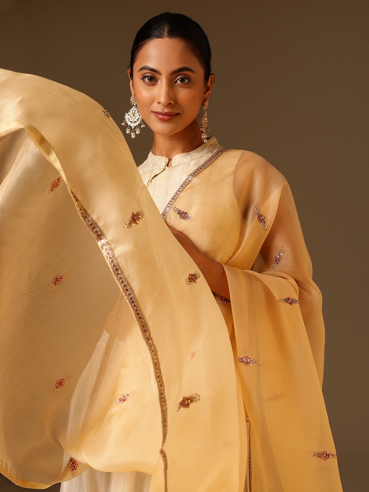 Detailed shot of beige silk dupatta showcasing hand-embroidered Zardozi patterns and rich fabric texture.