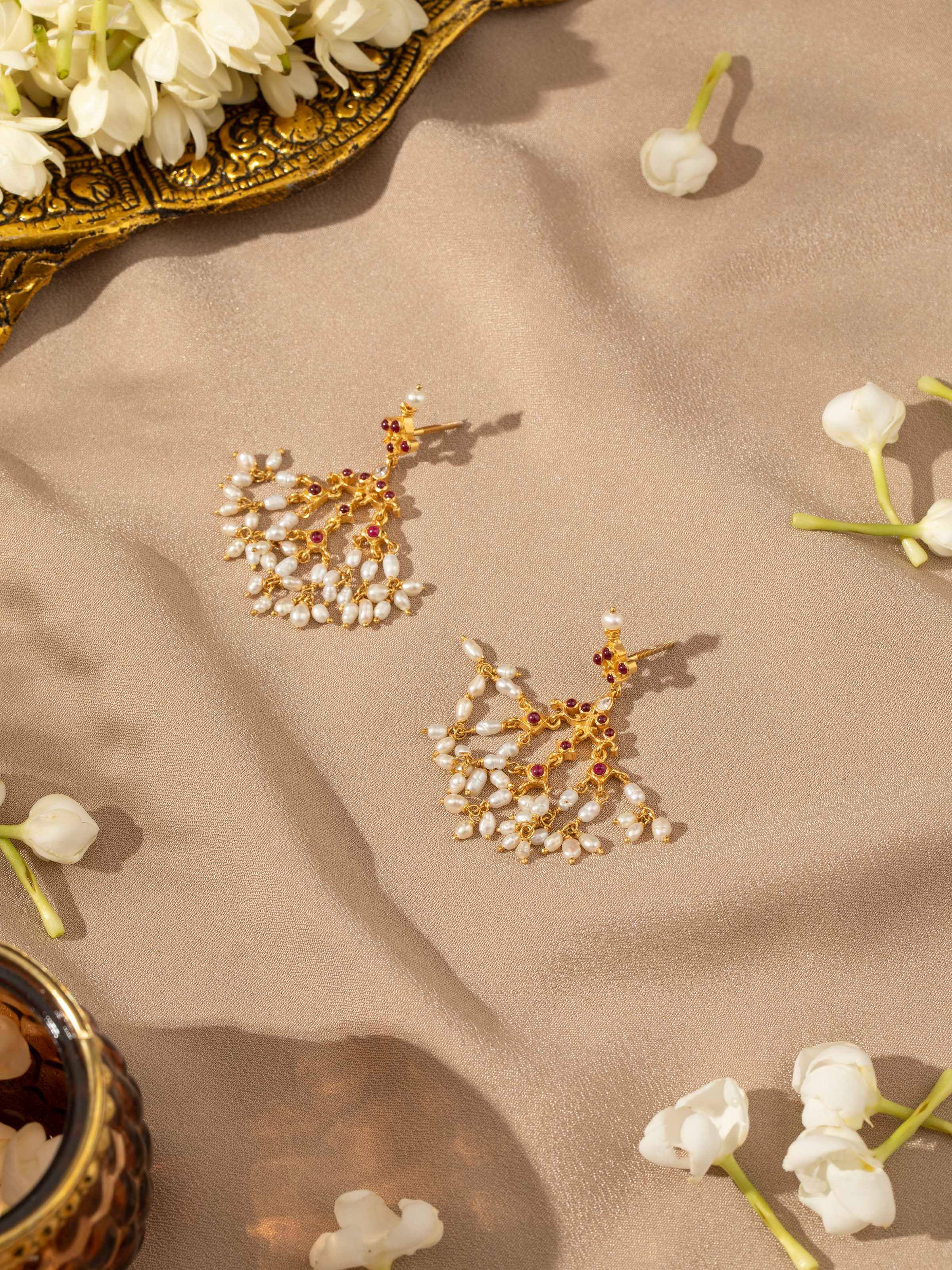 Overhead view of Guttapusalu silver earrings highlighting symmetry and pearl drops