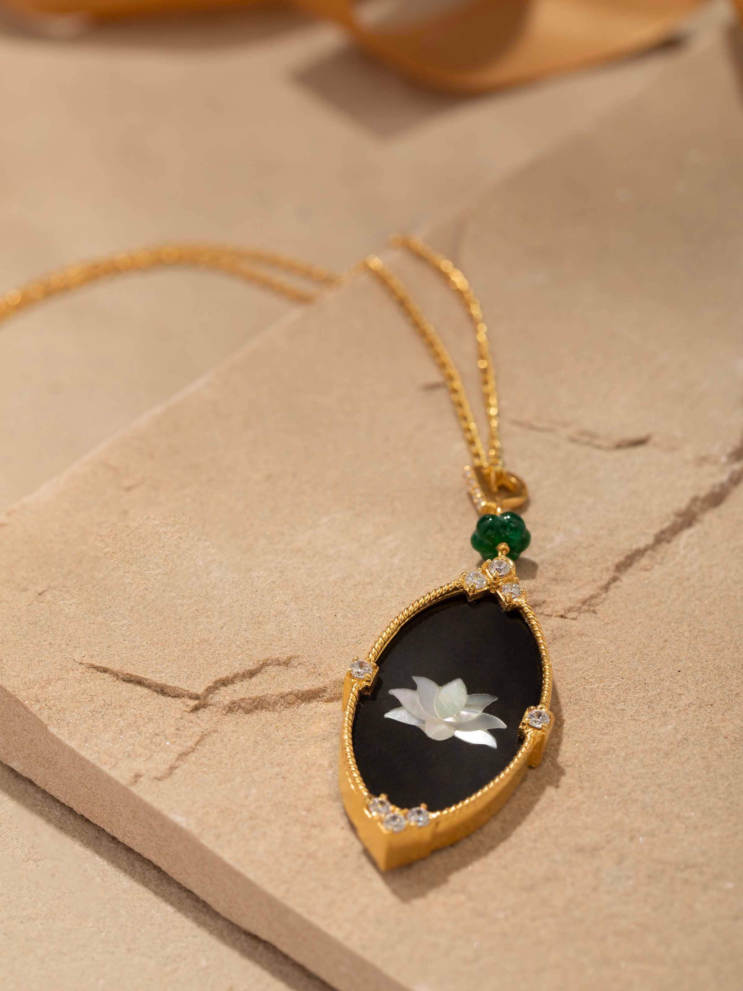 Detail shot of pendant showcasing fine enamel work and polished silver frame