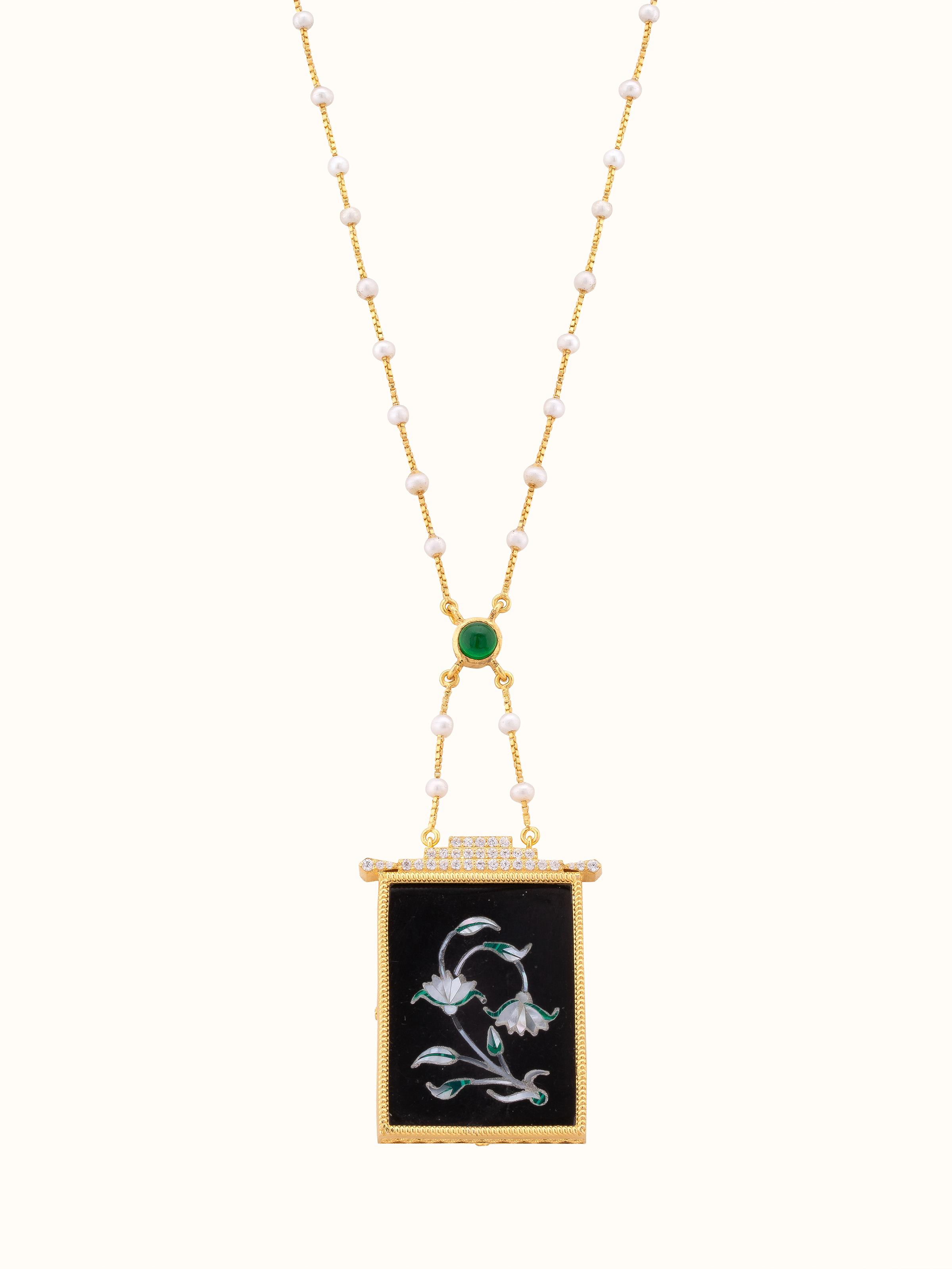 Front view of Pacchikari silver pendant and chain featuring intricate silverwork and a classic design.