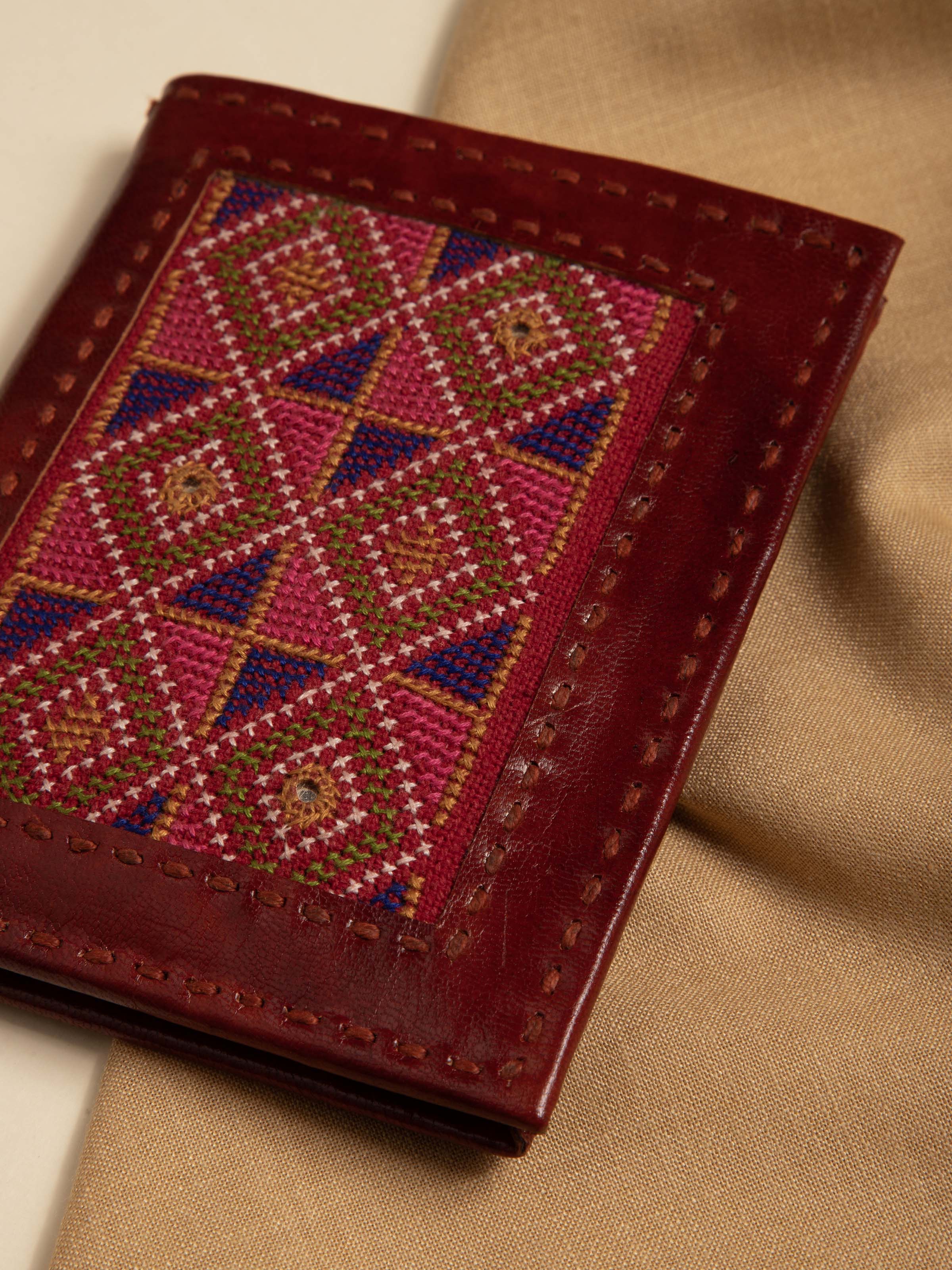 Close-up of tan Kutchi leather embroidered wallet focusing on the intricate embroidery and leather quality