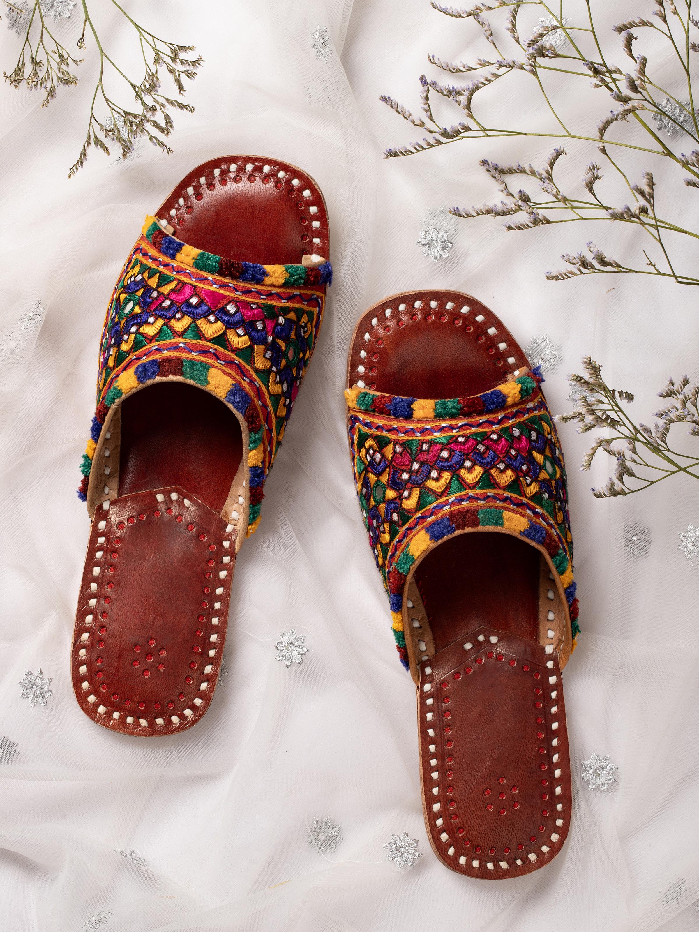 Side view of tan leather kutch embroidered slides showcasing the intricate design