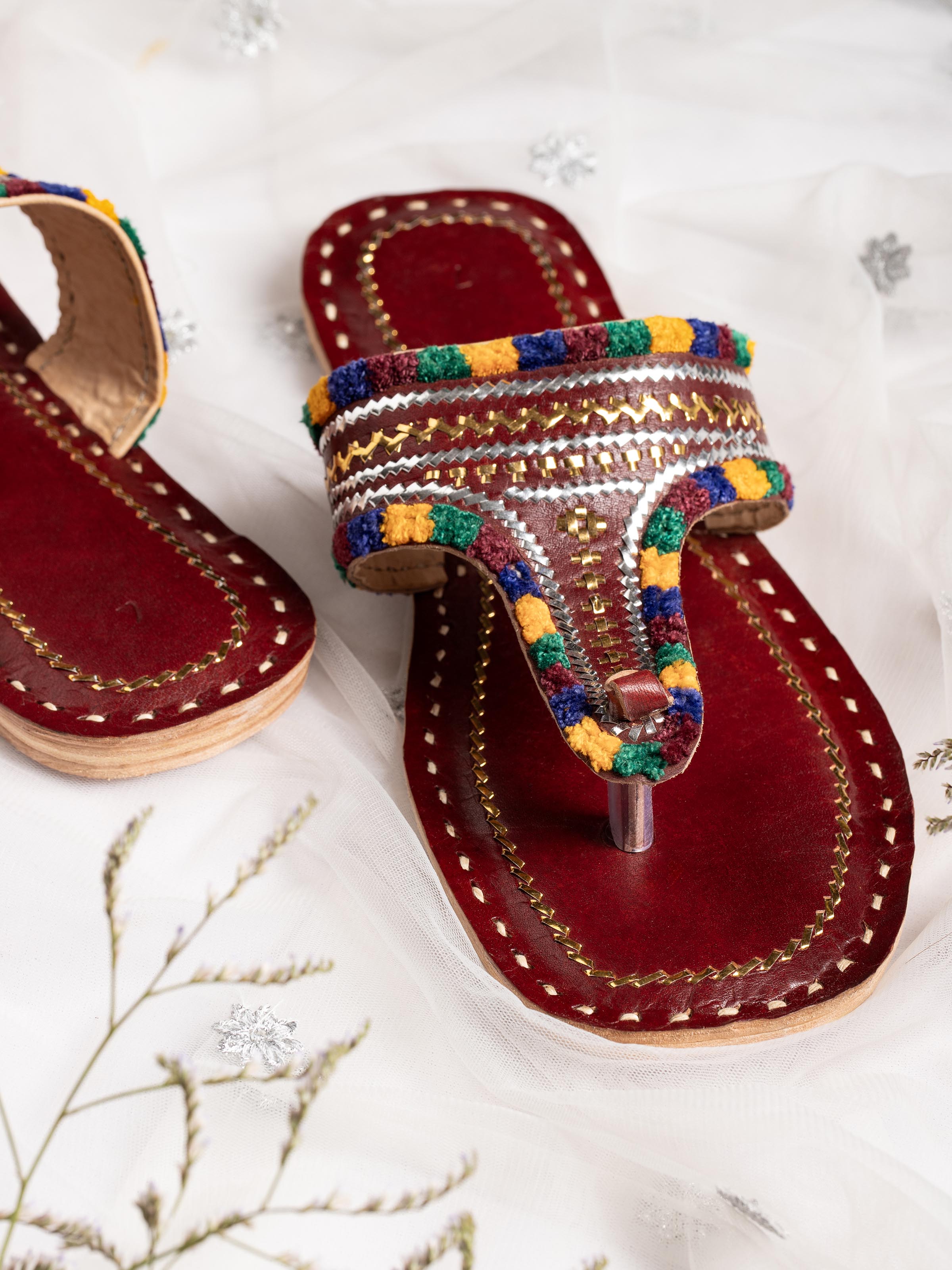 Top view of tan leather kutch stitched flats highlighting traditional craft details