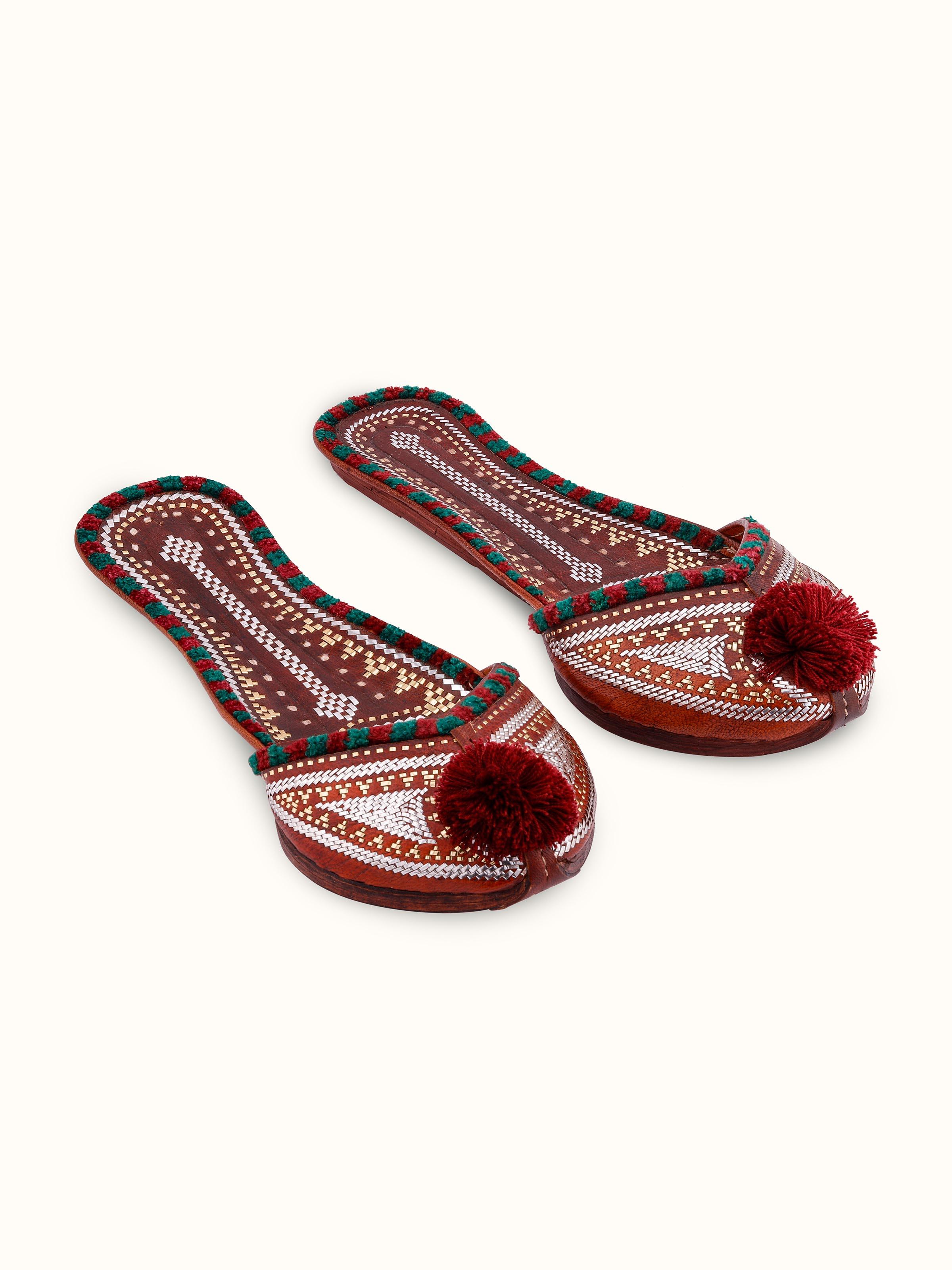 Front view of tan leather Kutch juttis showcasing intricate embroidery and traditional design