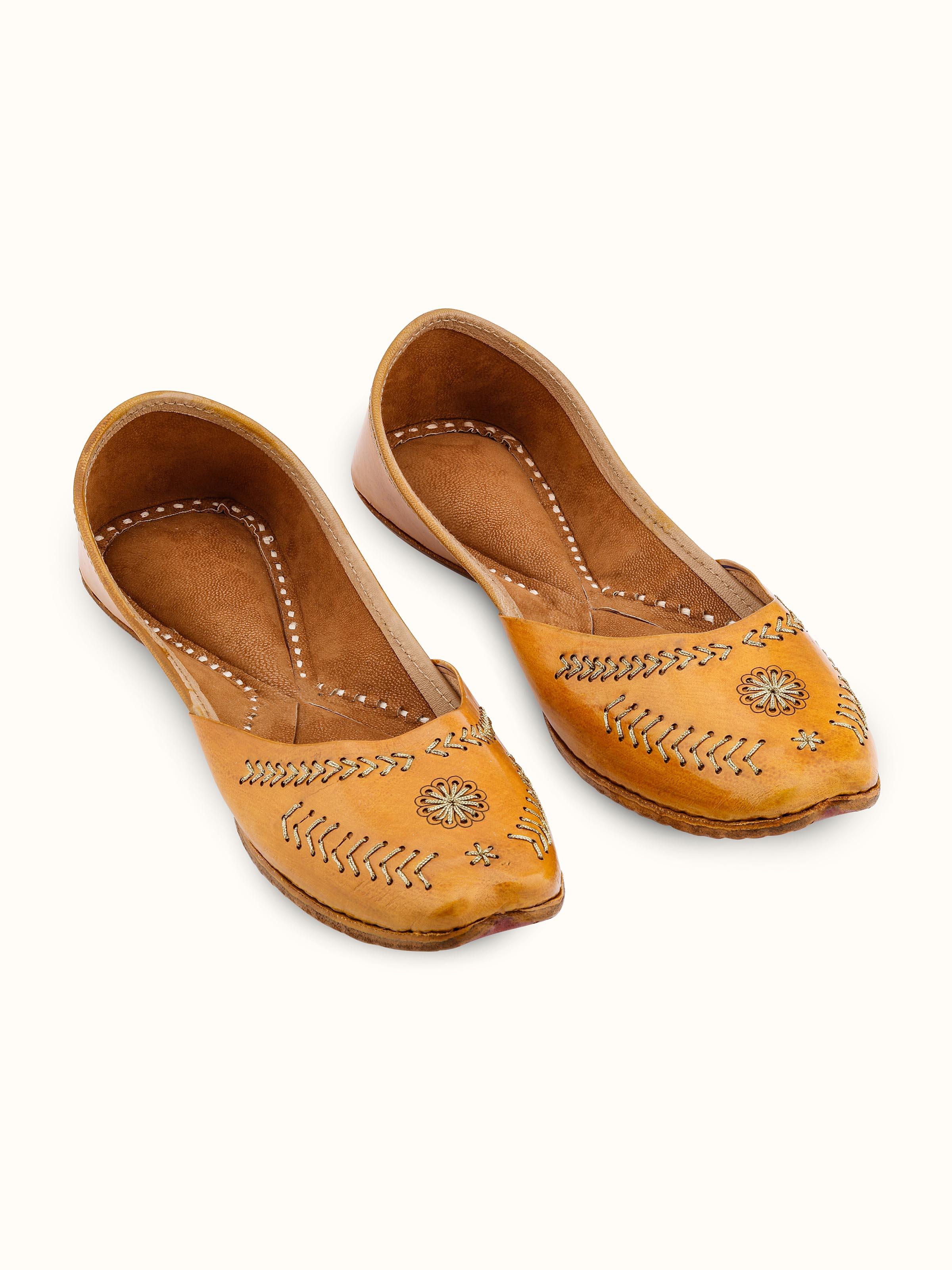 Front view of mustard leather Haryana juttis showcasing intricate embroidery and leatherwork