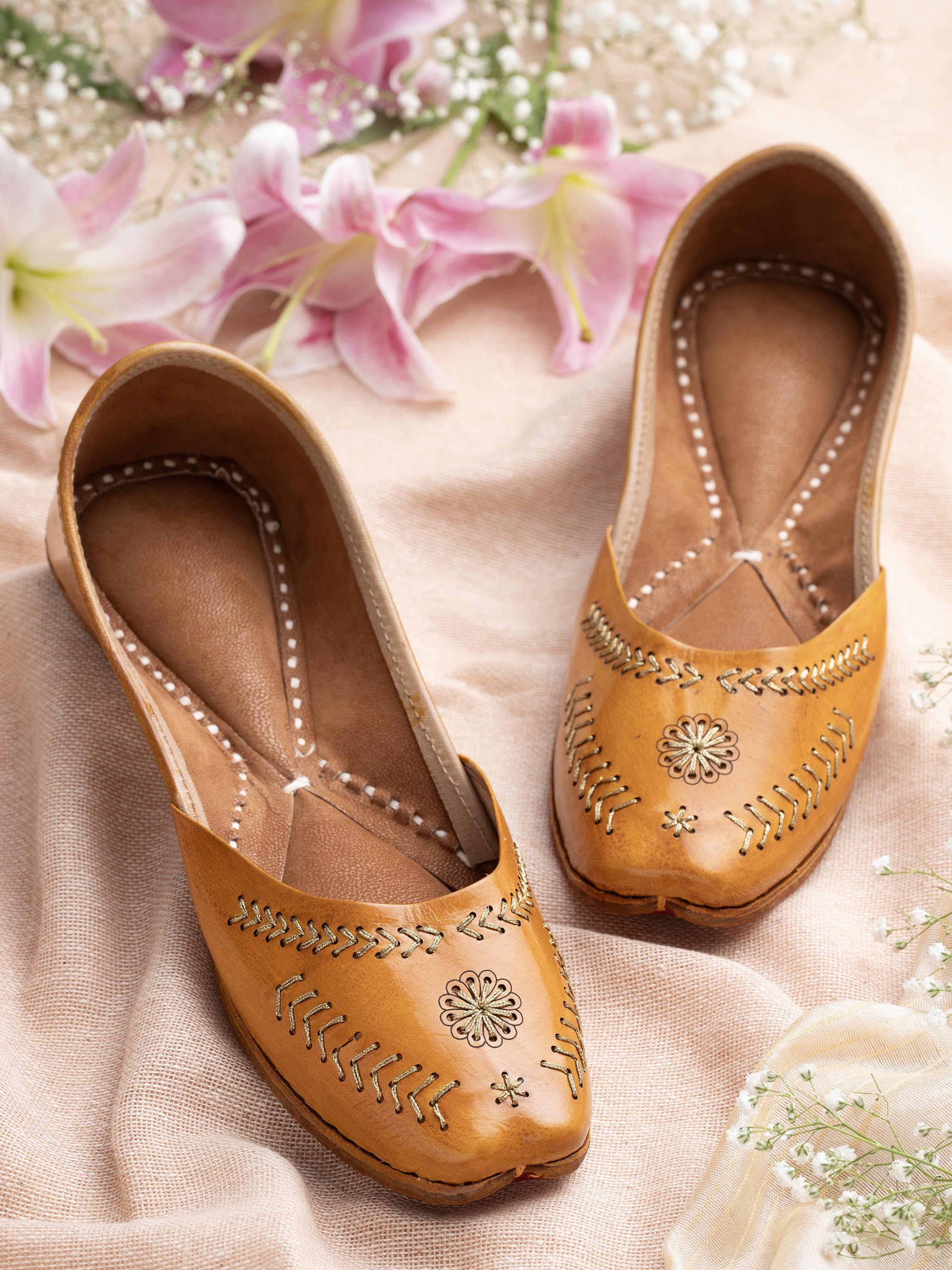 Side view of mustard leather Haryana juttis highlighting detailed craftsmanship and design