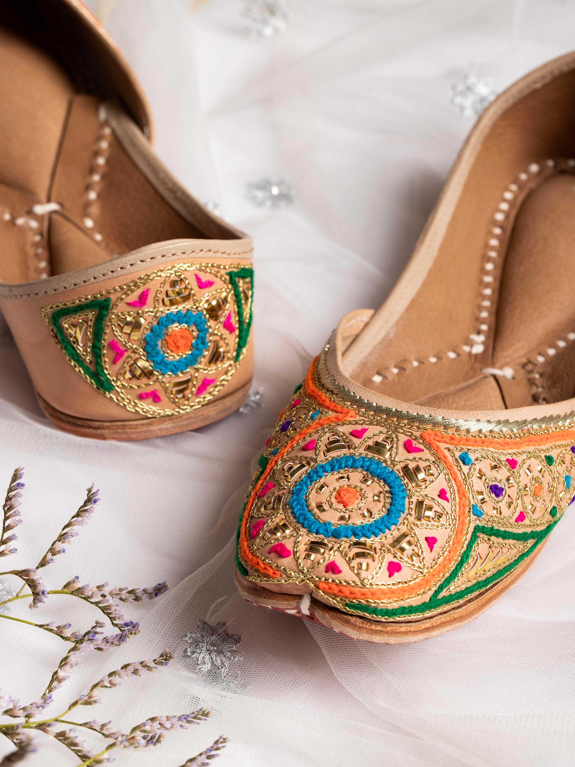 Close-up of Tan Leather Haryana Embroidered Juttis showing the fine embroidery work and texture.