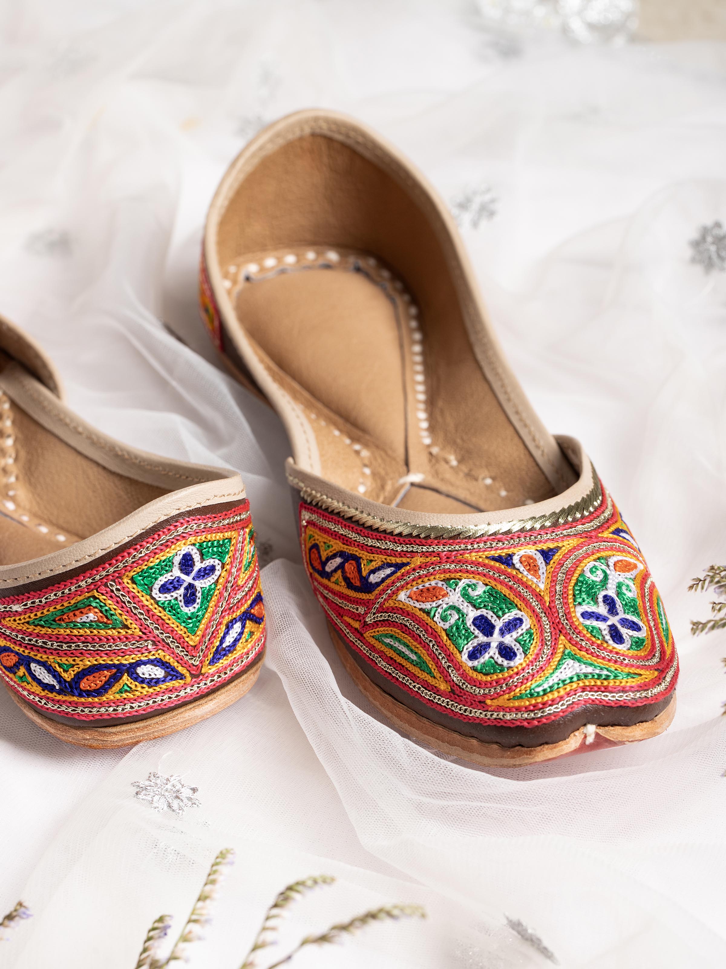 Detailed view of Tan leather haryana embroidered juttis highlighting stitching